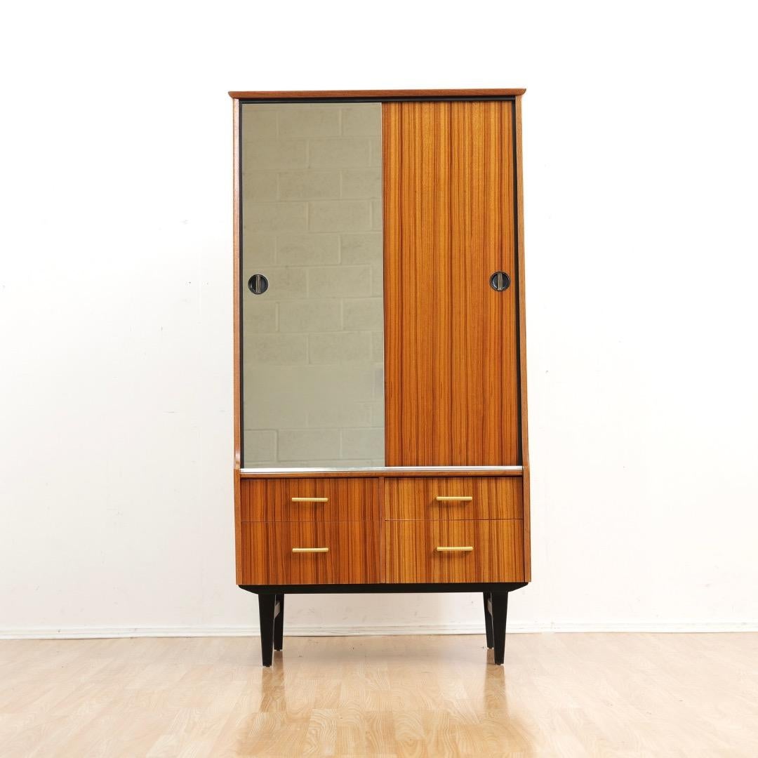 Mid Century Armoire Entworfen von Limelight Furniture, in den 1960er Jahren. Ein eleganter Kleiderschrank mit reichlich Stauraum für hängende Kleidungsstücke und 4 Schubladen. Mit einer verspiegelten Schiebetür auf der einen Seite und einer Holztür