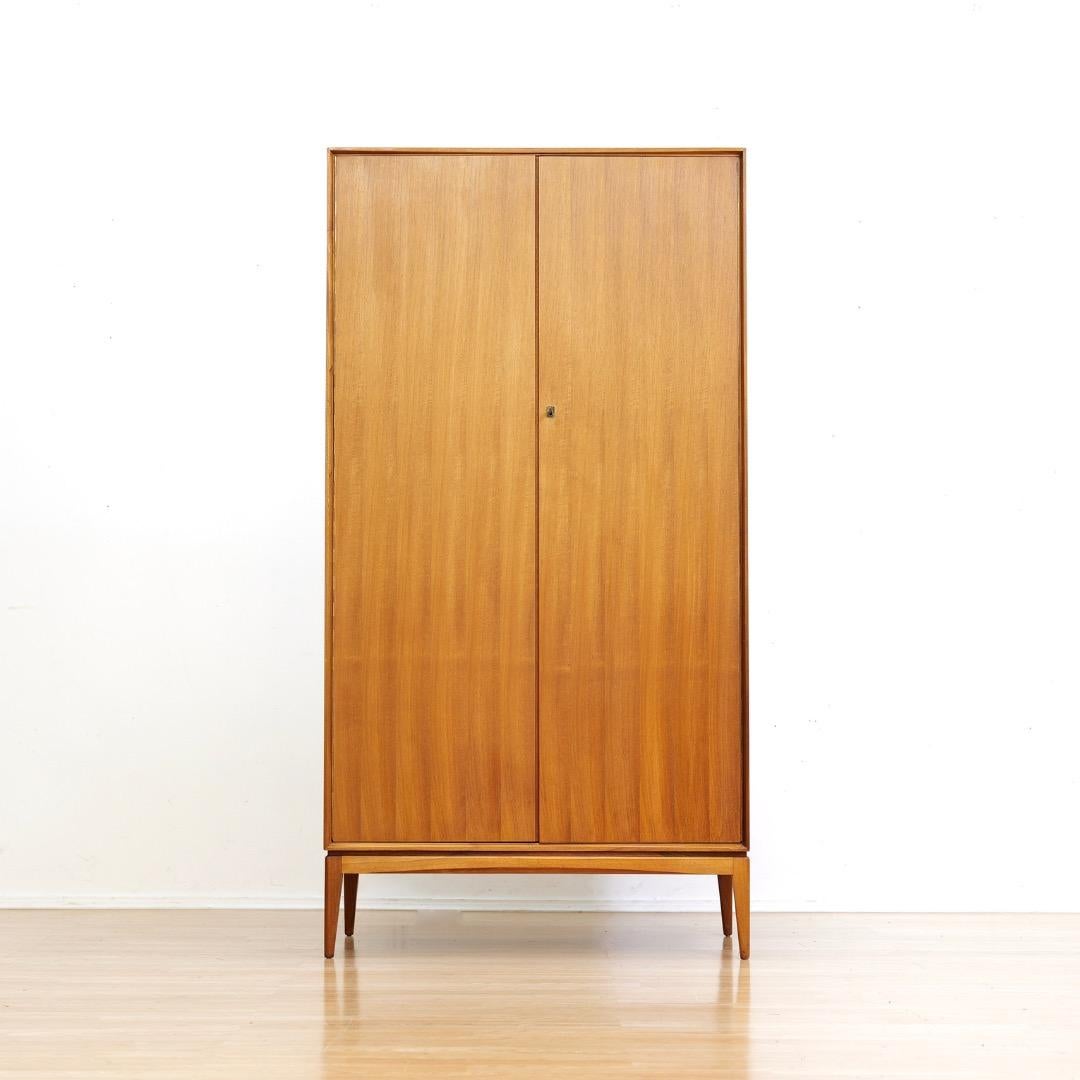 Questo armadio vintage della metà del secolo scorso è stato prodotto da McIntosh Furniture di Kirkcaldy, in Scozia, negli anni Sessanta. Realizzata in teak, le due ante anteriori incernierate si aprono per rivelare un ampio deposito di indumenti