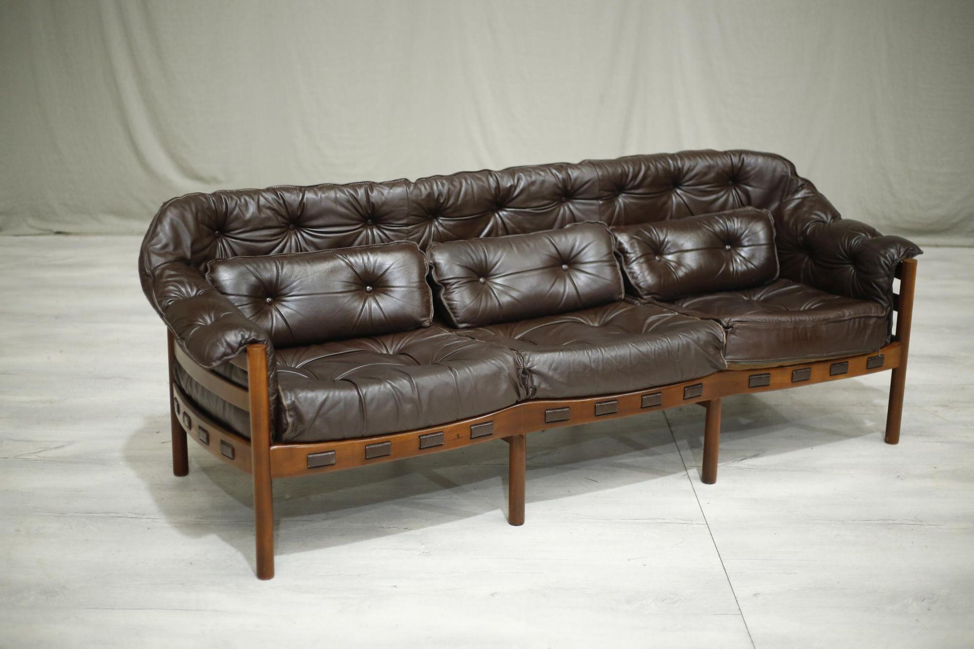 This is a very stylish mid century brown leather and teak sofa by Arne Norell. The quality is superb and you really sink into the seats comfortably. The design to me is ageless and will work well in a number of interiors. Good size and overall
