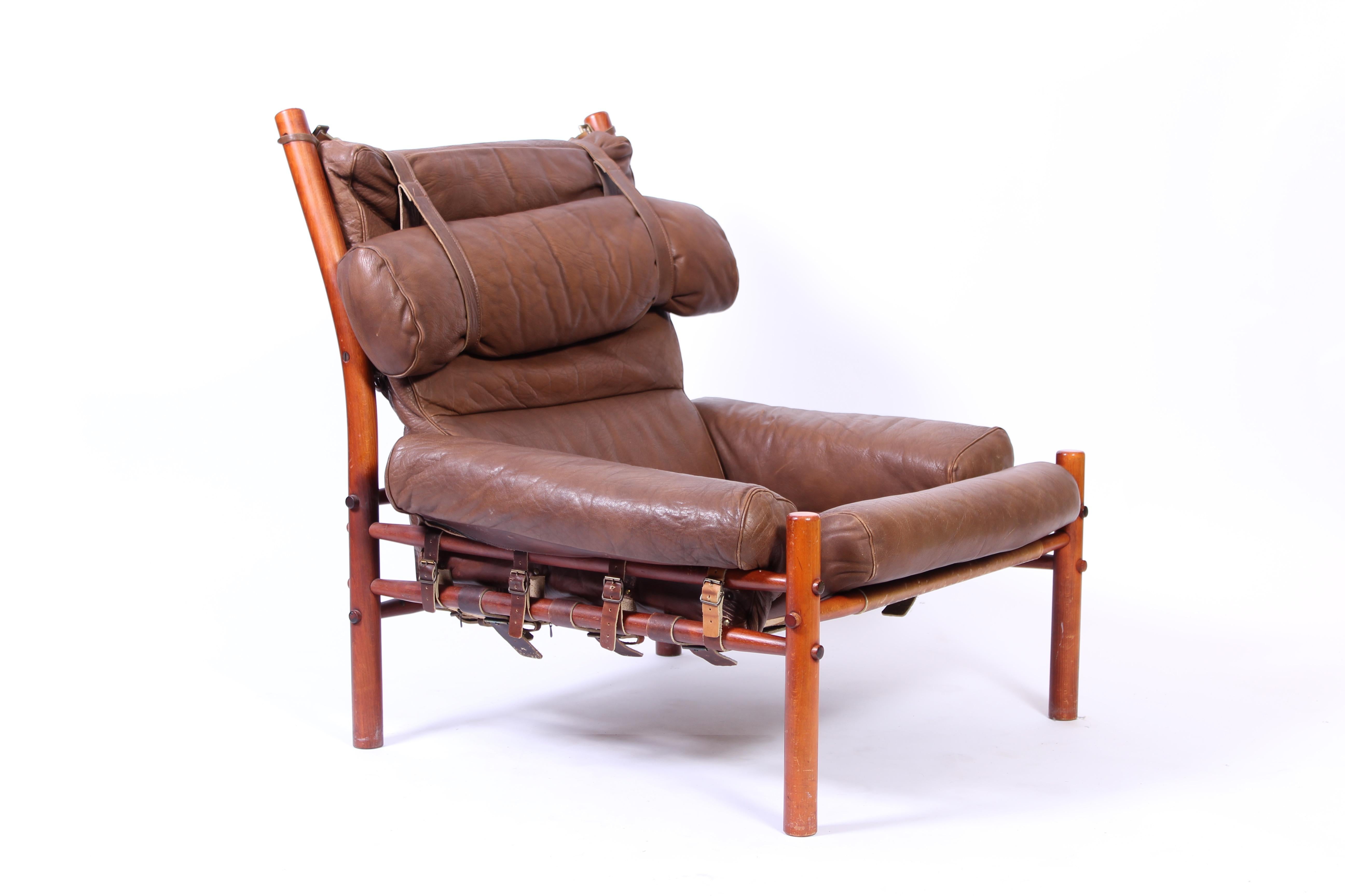 A buffalo leather lounge chair designed by Arne Norell and manufactured b his own company. The chair has a stained beech frame and leather seat and back connected with leather straps. The leather is original and shows signs of usage and patina