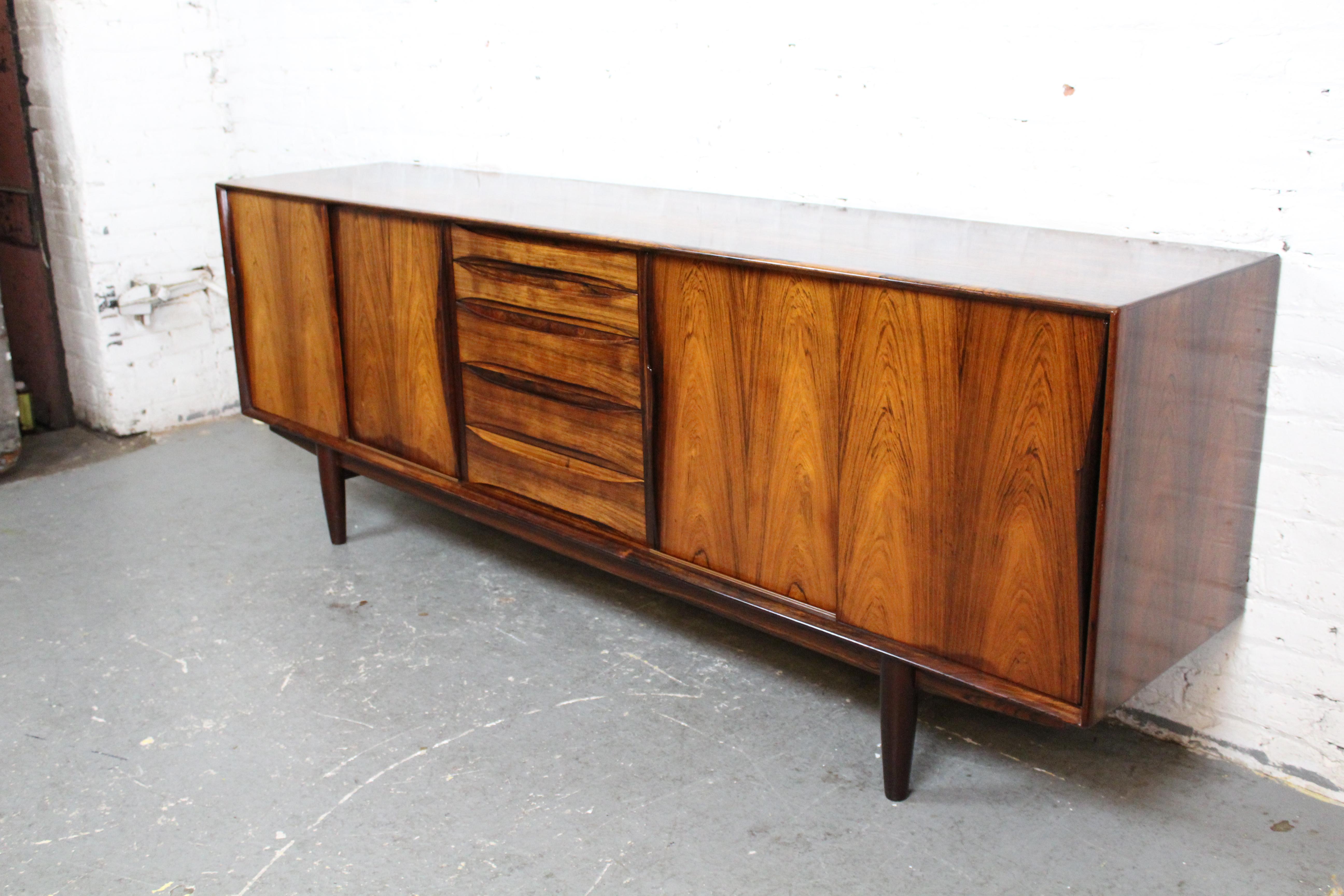 Ce buffet d'une qualité irréprochable est un meuble de style moderne danois du milieu du siècle. Conçue par le célèbre Arne Vodder pour la société danoise Skovby Møbelfabrik A/S, cette luxueuse mallette en bois de rose, modèle 7738, présente une