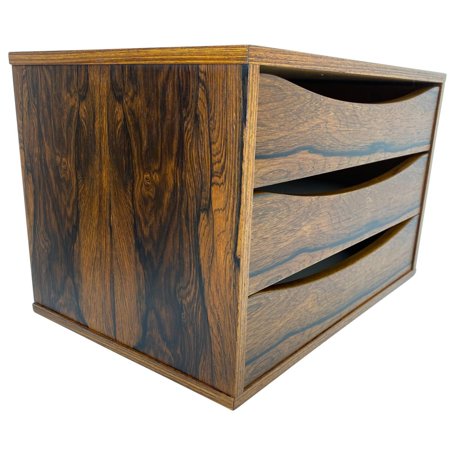 A Classic Scandinavian Modern refined and diminutive desk paper organizer in warm amazing rosewood, with three flush face drawers with arched cutout. The rack can certainly be used as a jewelry organizer as well.