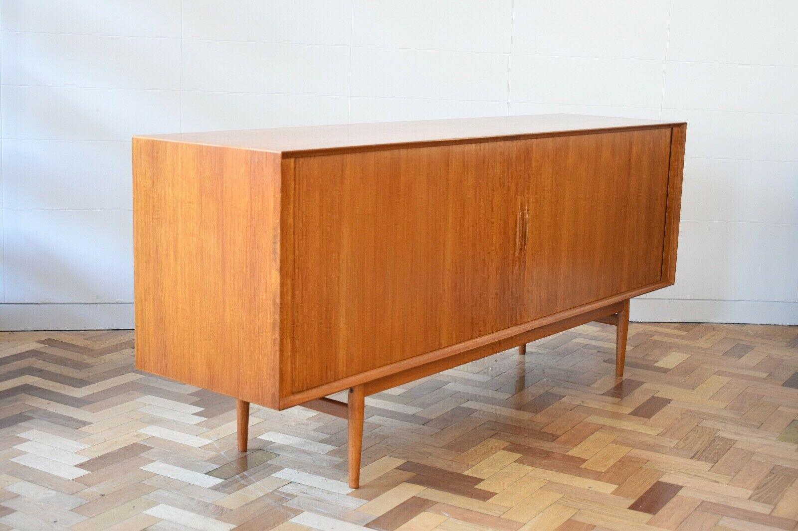 Splendid 1960s teak wood cradenza by Arne Vodder for Sibast Møbler. This minimalist design features impressively crafted tambour doors with laid sculpted handles which slide to reveal seven shelving compartments and three draws. The piece sits on