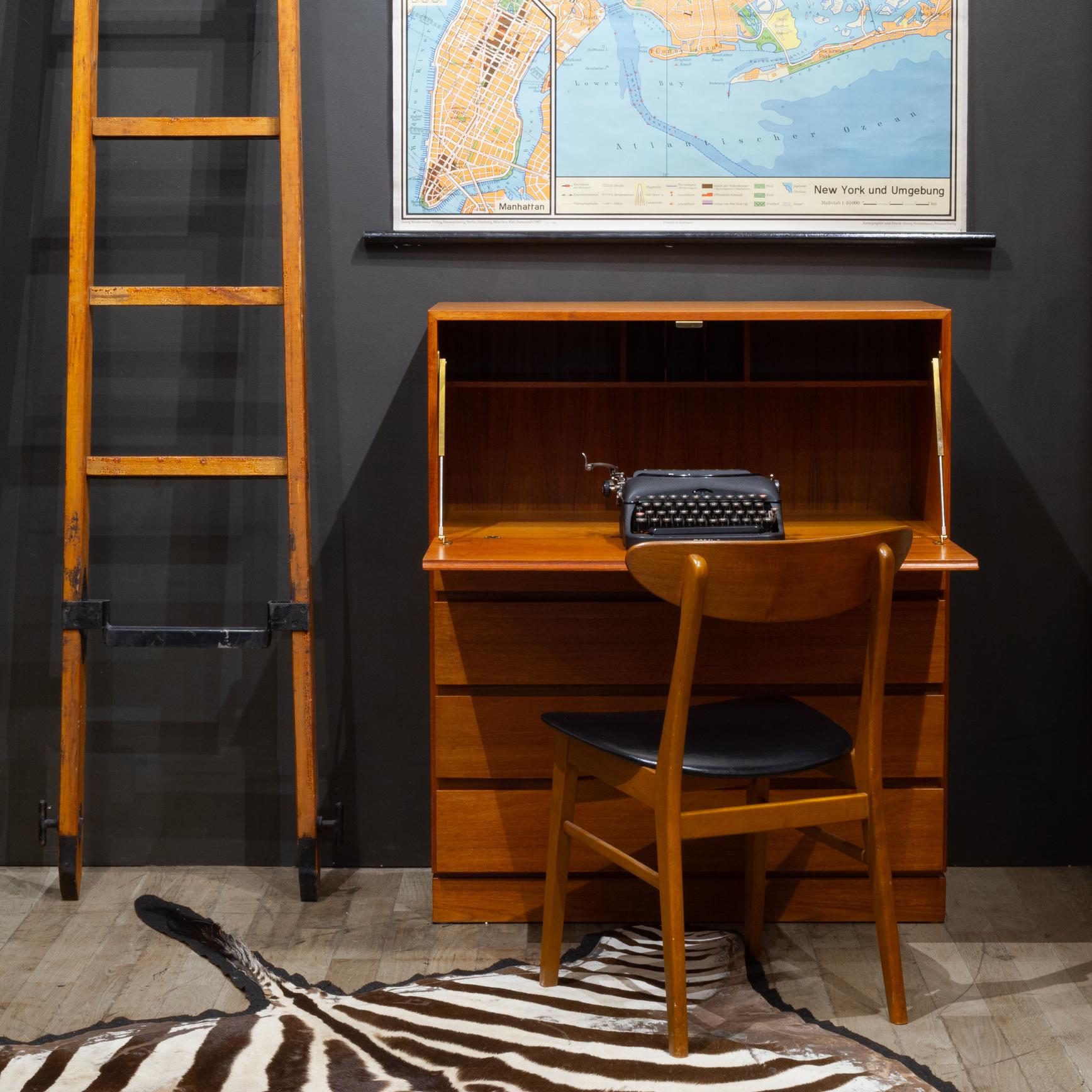 ABOUT

Mid-century Danish Teak desk with drop down door that reveals a large work area and three cubbies to store all your needs. Brass brackets and hinges secure the door as it's lowered. Two small drawers and three large drawers provide plenty of