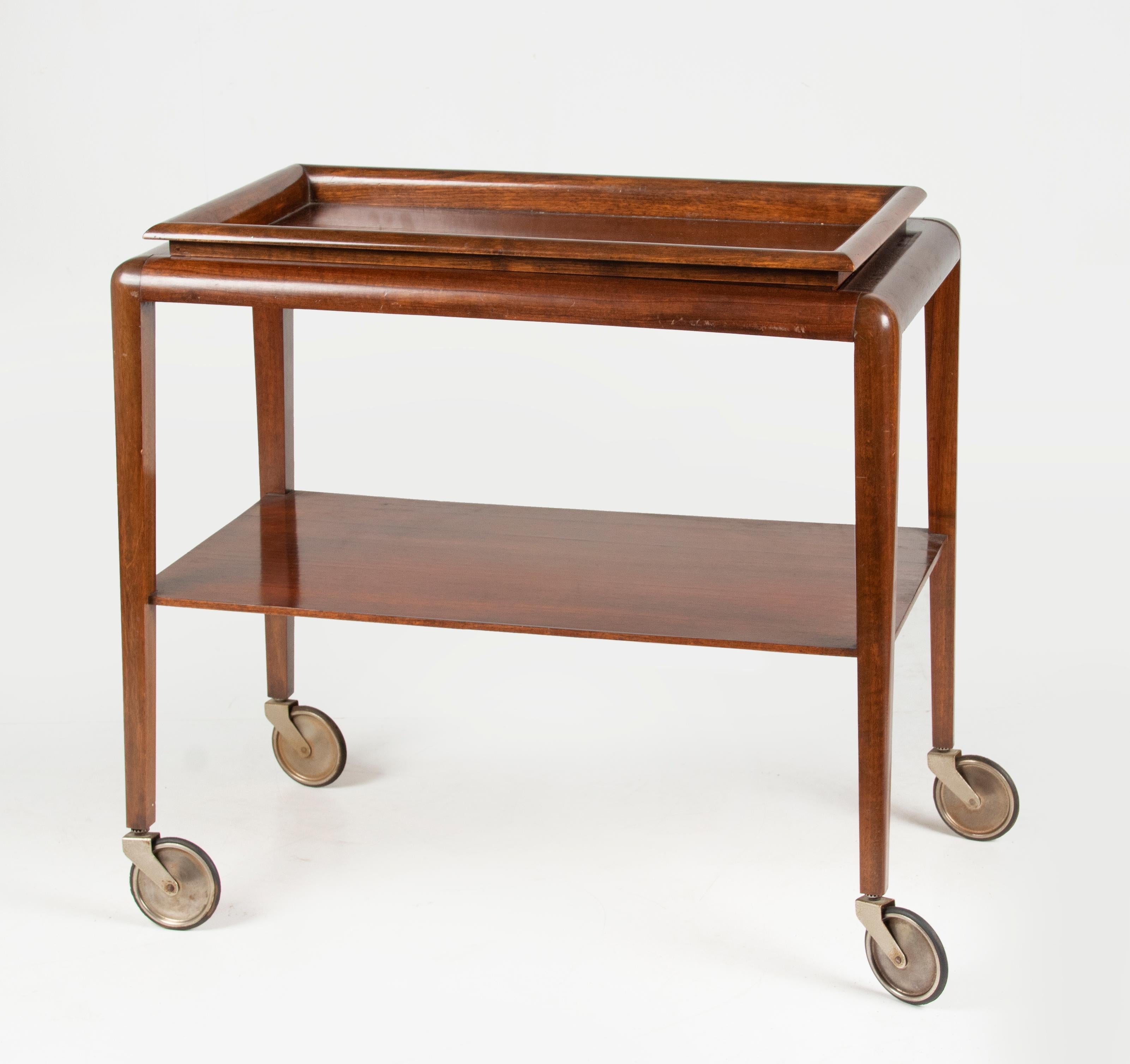 An elegant bar cart / trolley with a removable tray in Art Deco style. The trolley is made of beech wood. Tapered legs with iron swivel wheels. The tray has a glass top. Made in France, circa 1950-1960.