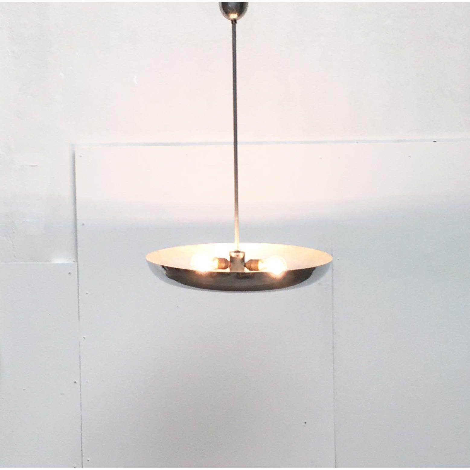 Imponente lampada a sospensione da bar.

Un design elegante e di particolare matericità. Uno Zusammspiel di vetro e alluminio speculare. Lo scudo è costituito da un vassoio di alluminio piatto. La conchiglia è montata centralmente su un'asta che