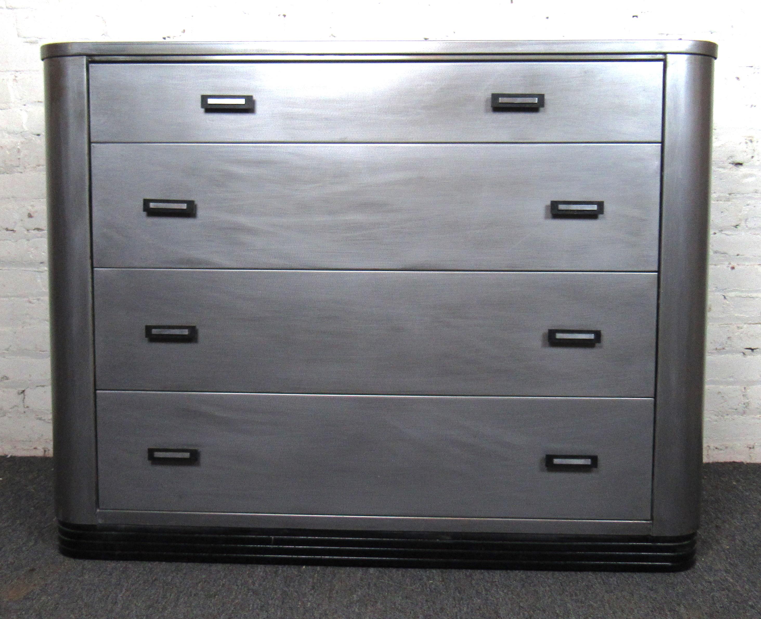 Unique vintage metal dresser produced by Simmons Company Furniture. This dresser features four spacious drawers with beautiful metal and black lacquered hardware. Rounded corners and black base with horizontal metal strips gives this piece a