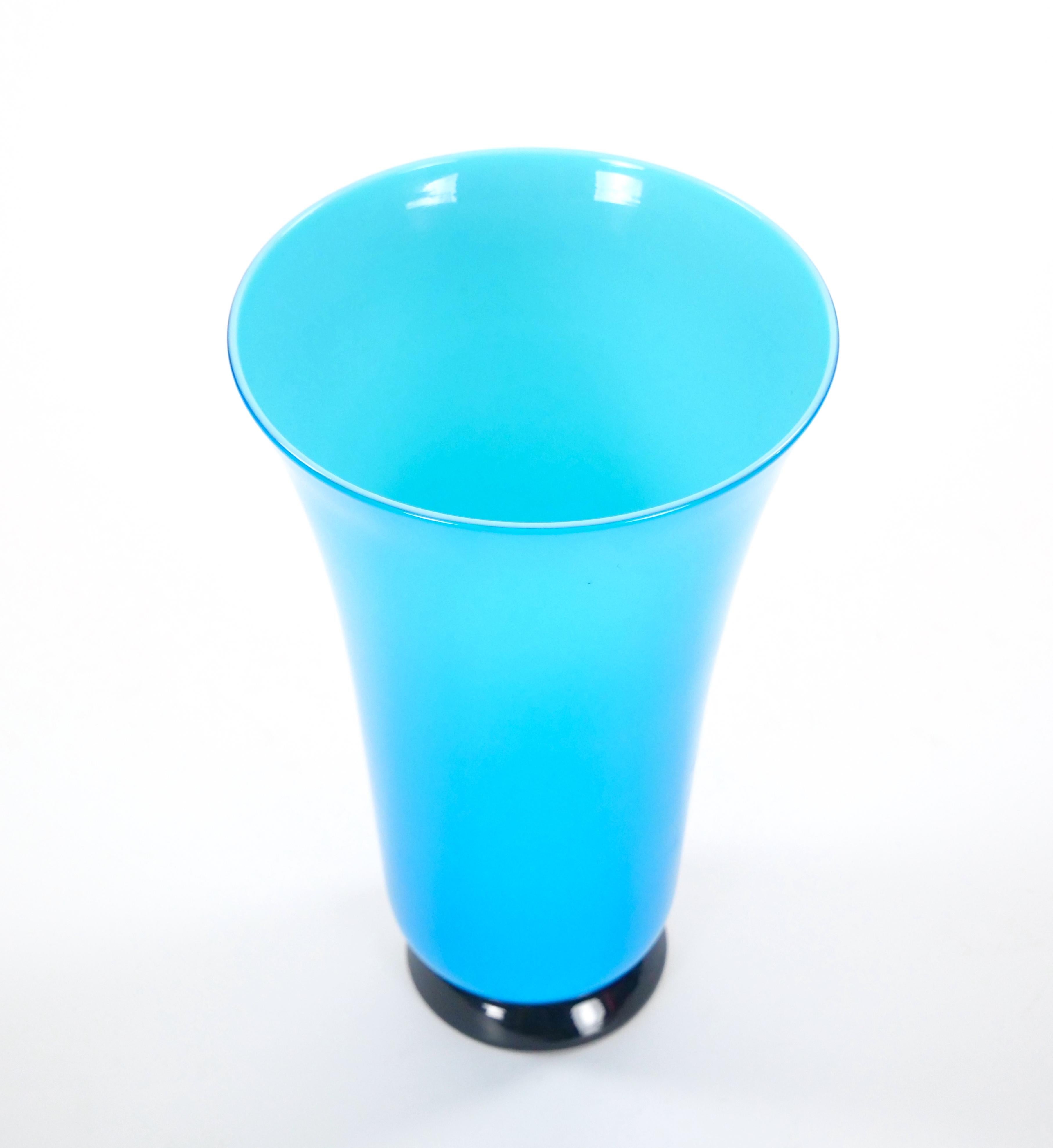 Ce vase en verre de Murano du milieu du siècle incarne l'élégance et les lignes épurées du style Art déco. Le corps du vase est d'un turquoise profond et vibrant, contrasté par une base noire élégante, ce qui en fait un ajout étonnant et une touche