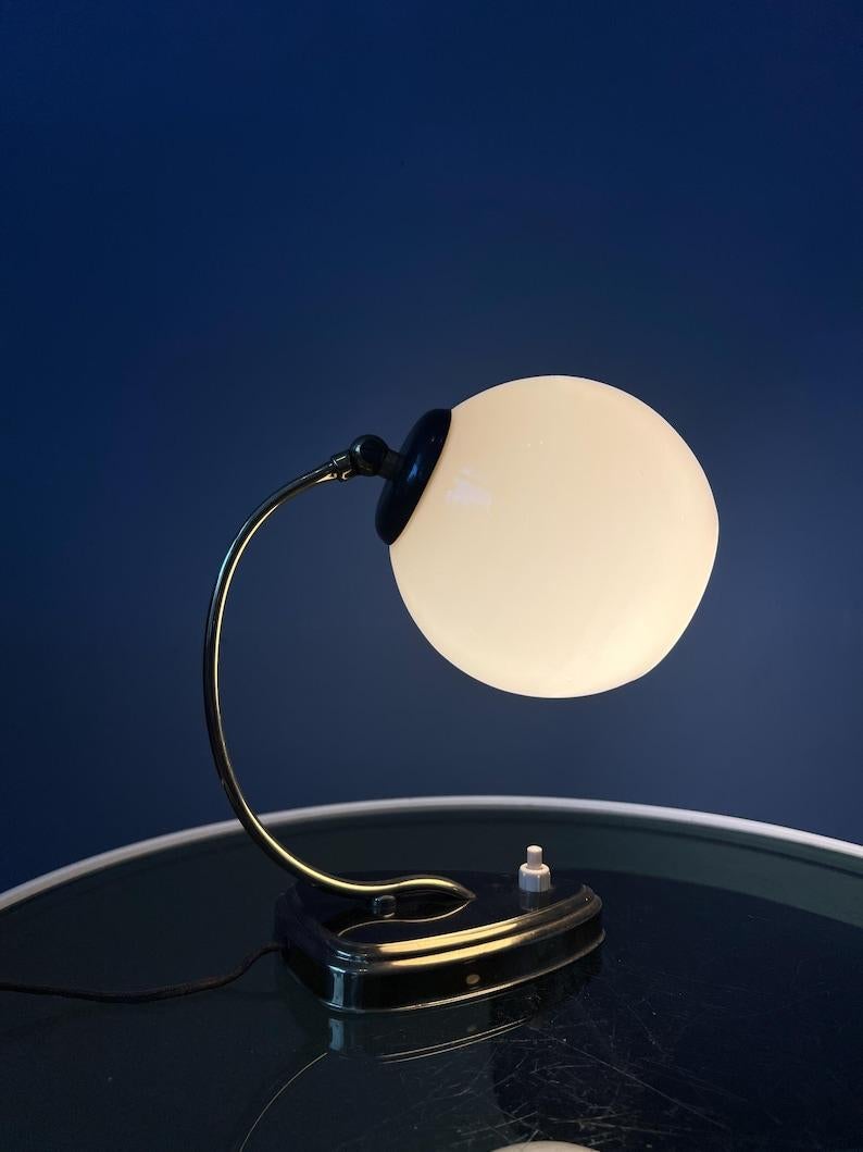Wand- oder Schreibtischlampe im Art-déco-Stil aus der Mitte des Jahrhunderts mit glänzendem Glasschirm. Das Stück hat einen schwarz-messingfarbenen Rahmen. Das Stück ist ursprünglich eine Wandleuchte, kann aber auch als Tischleuchte verwendet