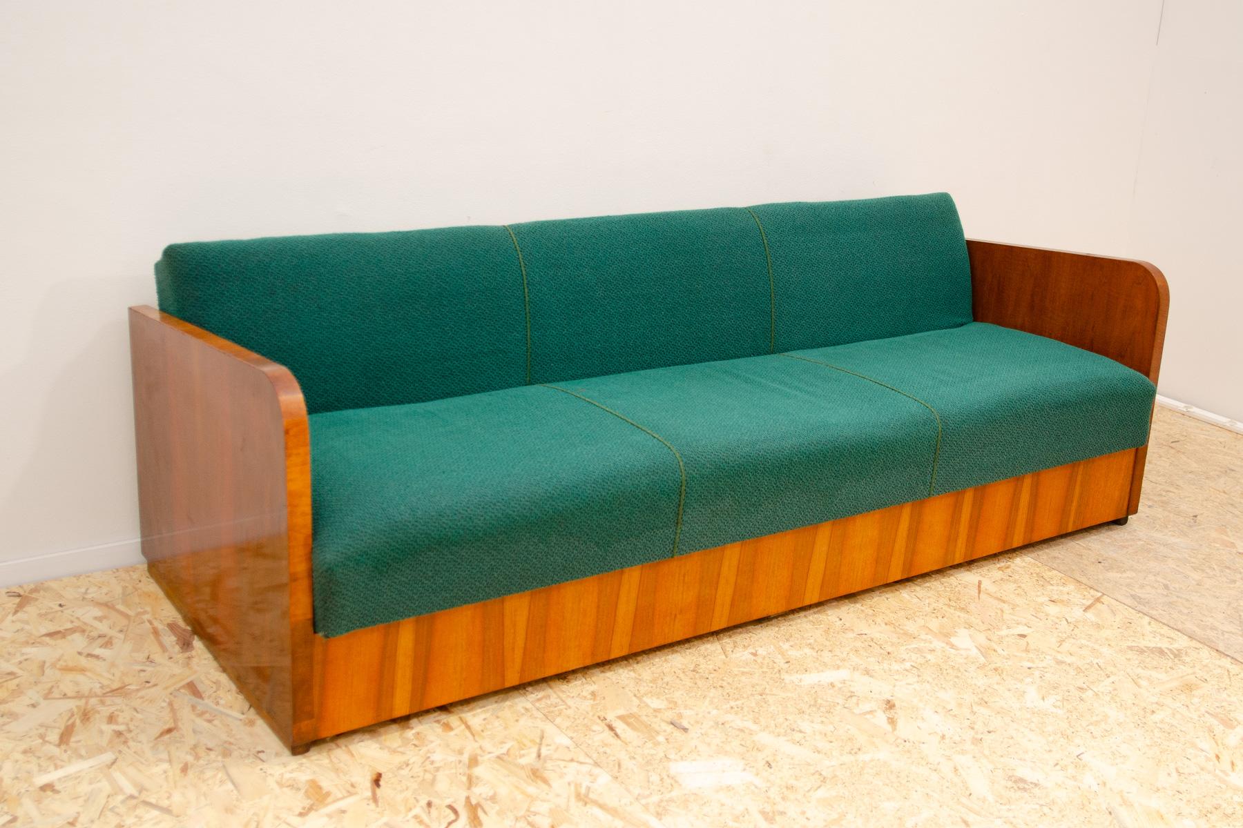 This sofabed was made by UP Závody in the former Czechoslovakia in the 1950´s.

You can easily fold the sofa into a bed.

This sofa has a wooden frame with a nice walnut veneer, it´s in good Vintage condition, the mattresses are faded in places, but