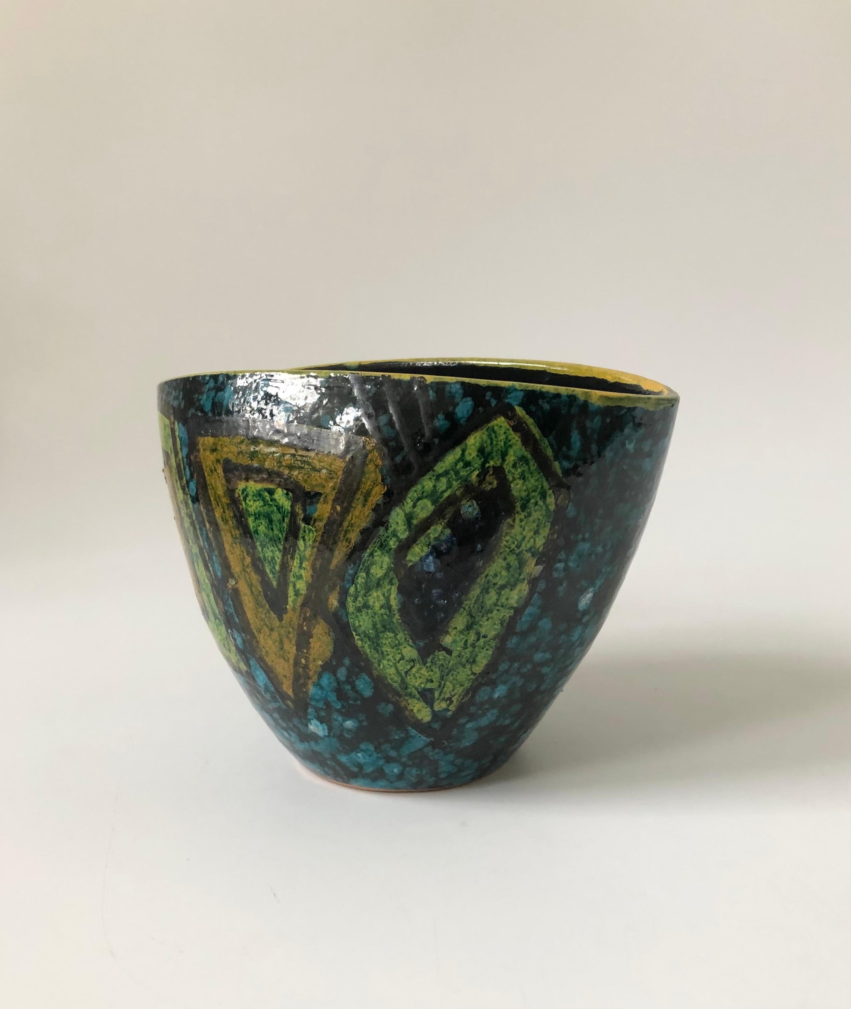 A mid century handmade art pottery vase. Nice tapered triangular shape with a graphic hand painted design in blue and green glazes. Similar in quality to mcm art pottery by Raymor or Bitossi. Unsigned.
 