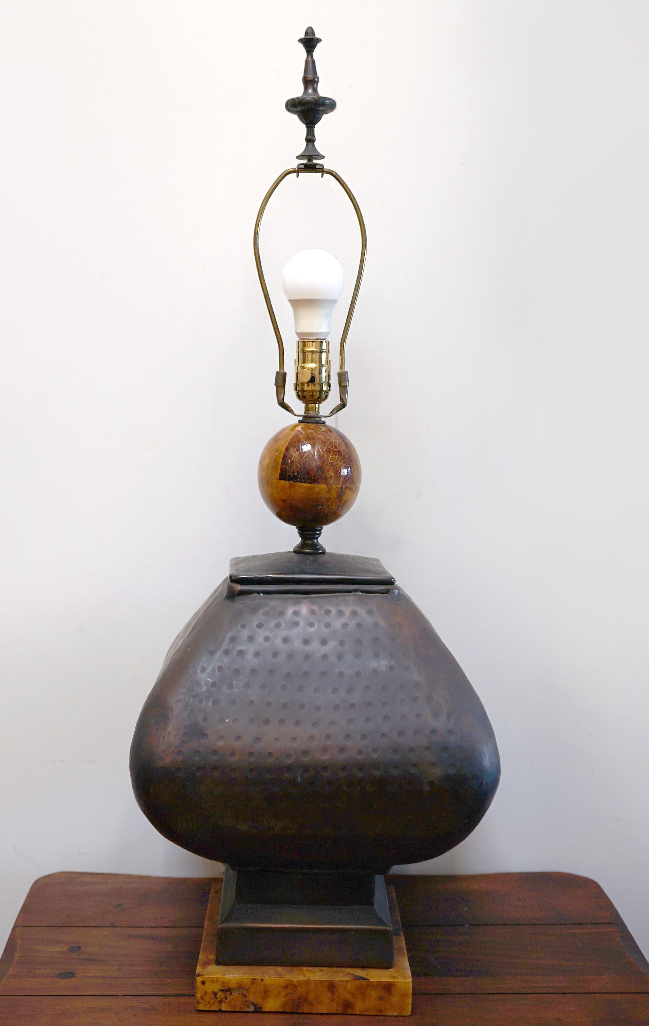 The hand-hammered pattern on the bronze and copper surface of this lamps makes it quite memorable. It has an architectural feel and a geometric body shape. A vintage Art Studio hammered copper table lamp
mid 20th Century
The rounded square-section
