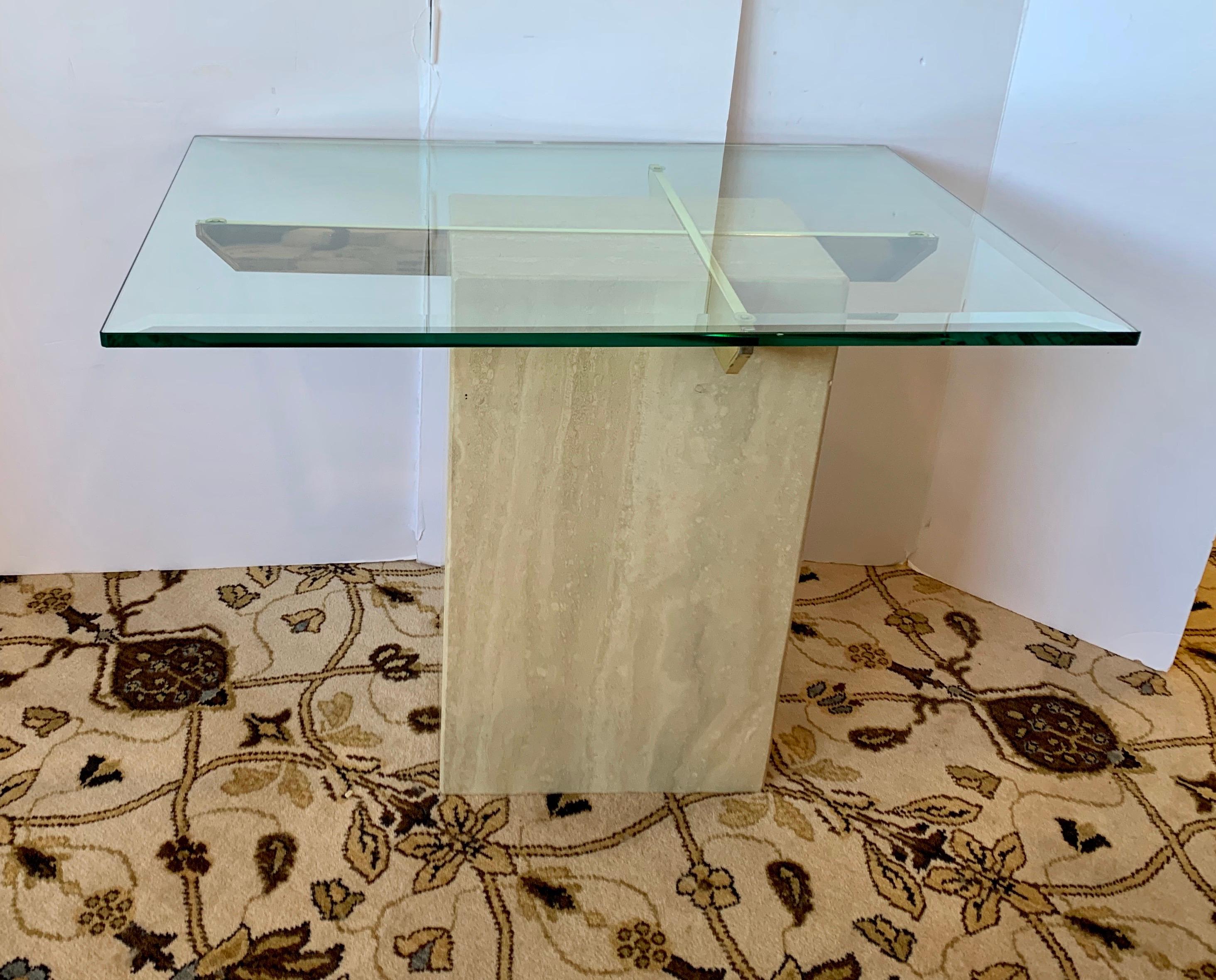Magnificent Mid-Century Modern Artedi side table features a thick rectangular glass top with a travertine base. Sleek design with two brass supports fitted inside the travertine marble base holds the large glass tabletop. This elegant piece makes