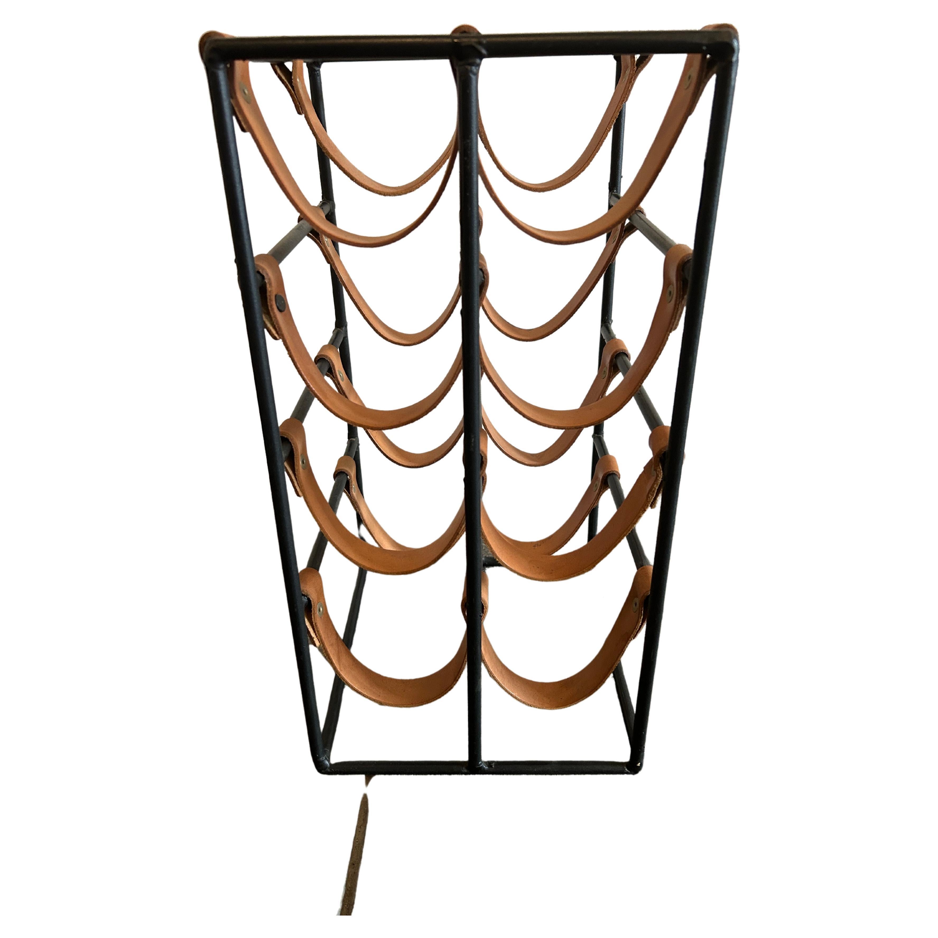 Arthur Umanoff for Shaver Howard 1950s iron and leather strap wine rack. Leather straps are solid.

Holds 8 Bottles of wine.

Measures: Height: 19 in
Width: 10 in
Depth: 9.5 in.