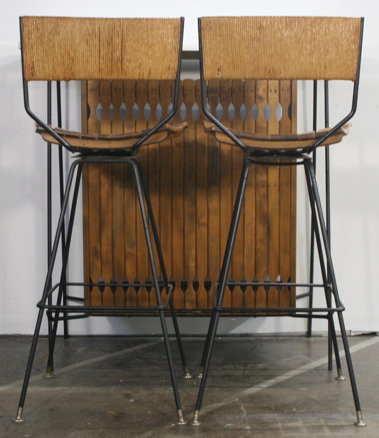 Midcentury Arthur Umanoff dry bar set for Raymor with 2 stools Iron and wood. Amazing condition Totally restored bar and 2 stools. All original bar with white laminate top and 2 open bar shelves. 2 iron stools with papercord backs - both stools