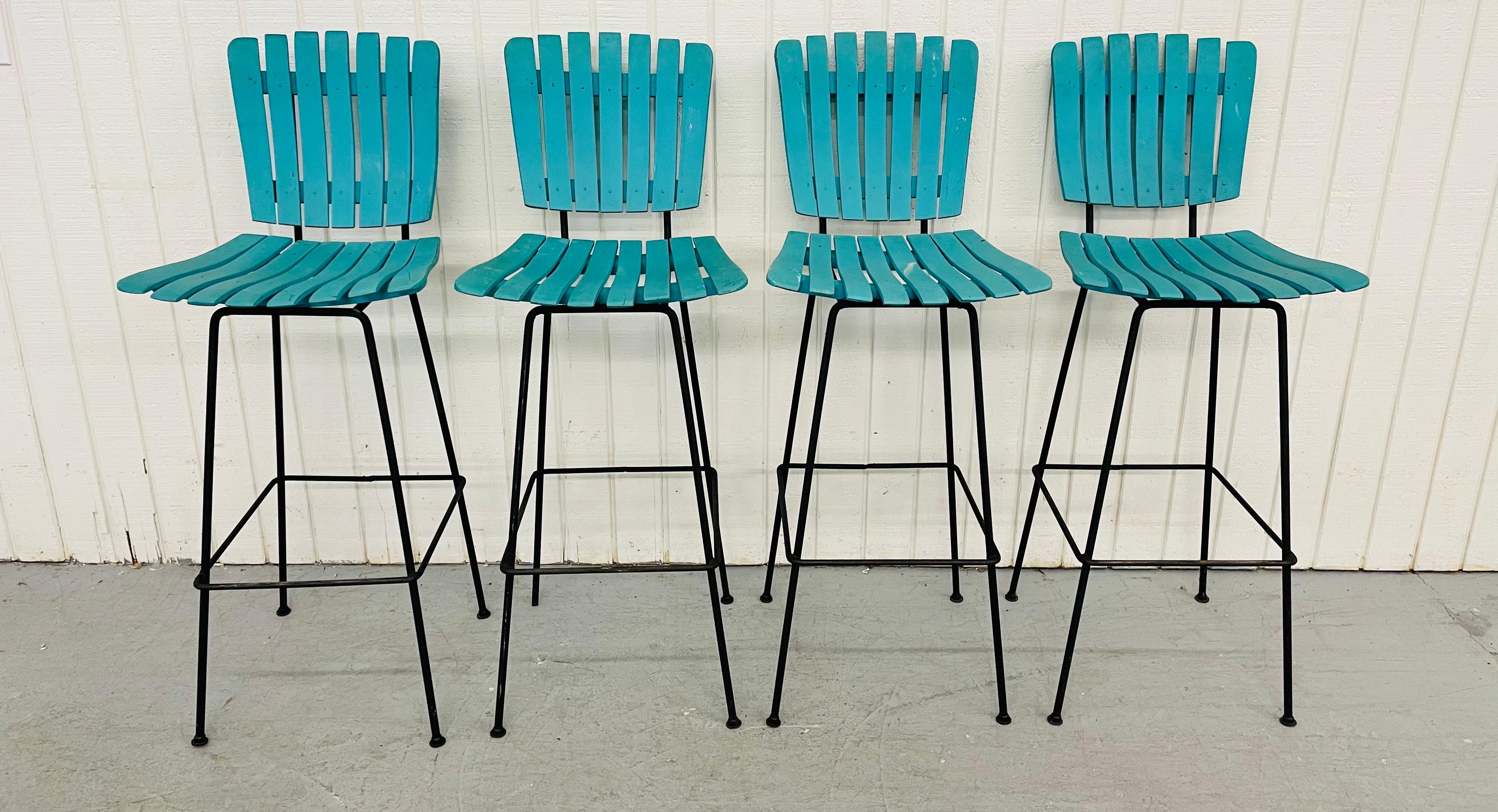 This listing is for a set of four Mid-Century Arthur Umanoff Slatted bar stools. Featuring an iron frame, vintage turquoise paint over the walnut slatted seat and backrest.
