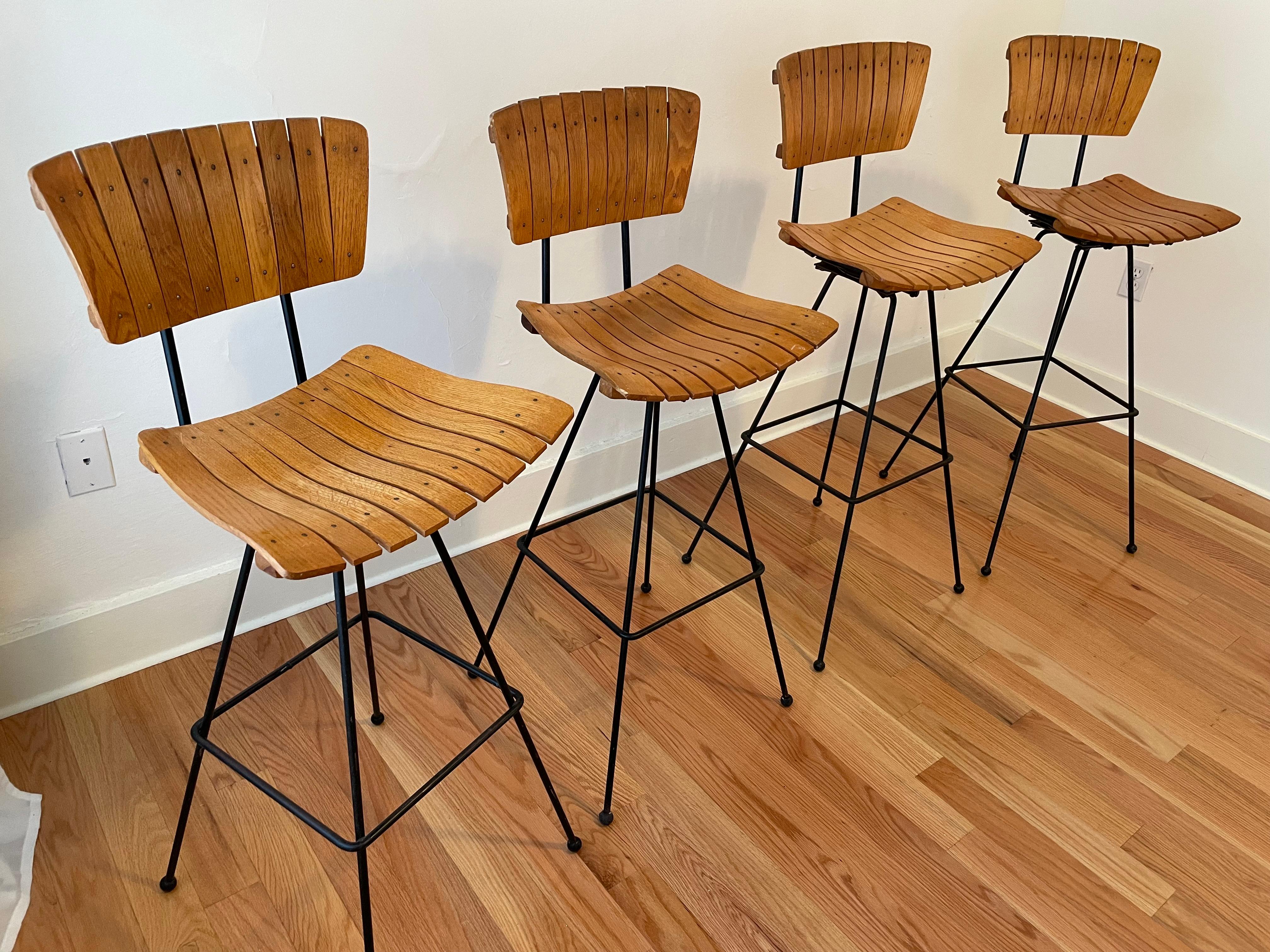 4 Arthur Umanoff bar stools in remarkable condition.  Varnish is mostly intact and steel only has a few spots of rust. Ball bearing swivels need lubrication but are all functional.

Height: 42 in (106.68 cm)Width: 17 in (43.18 cm)Depth: 17 in (43.18