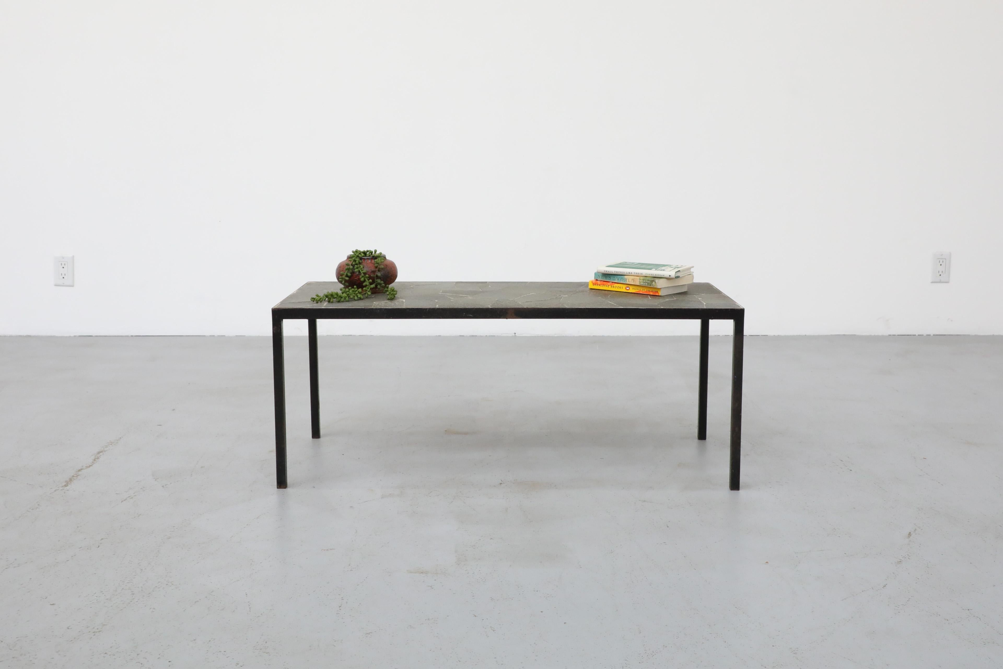 Mid-Century rectangular coffee table with black enameled metal frame and mixed gray stone mosaic top by Artimeta. A handsome versatile table with style and symmetry. In original condition with visible wear consistent with its age and use.