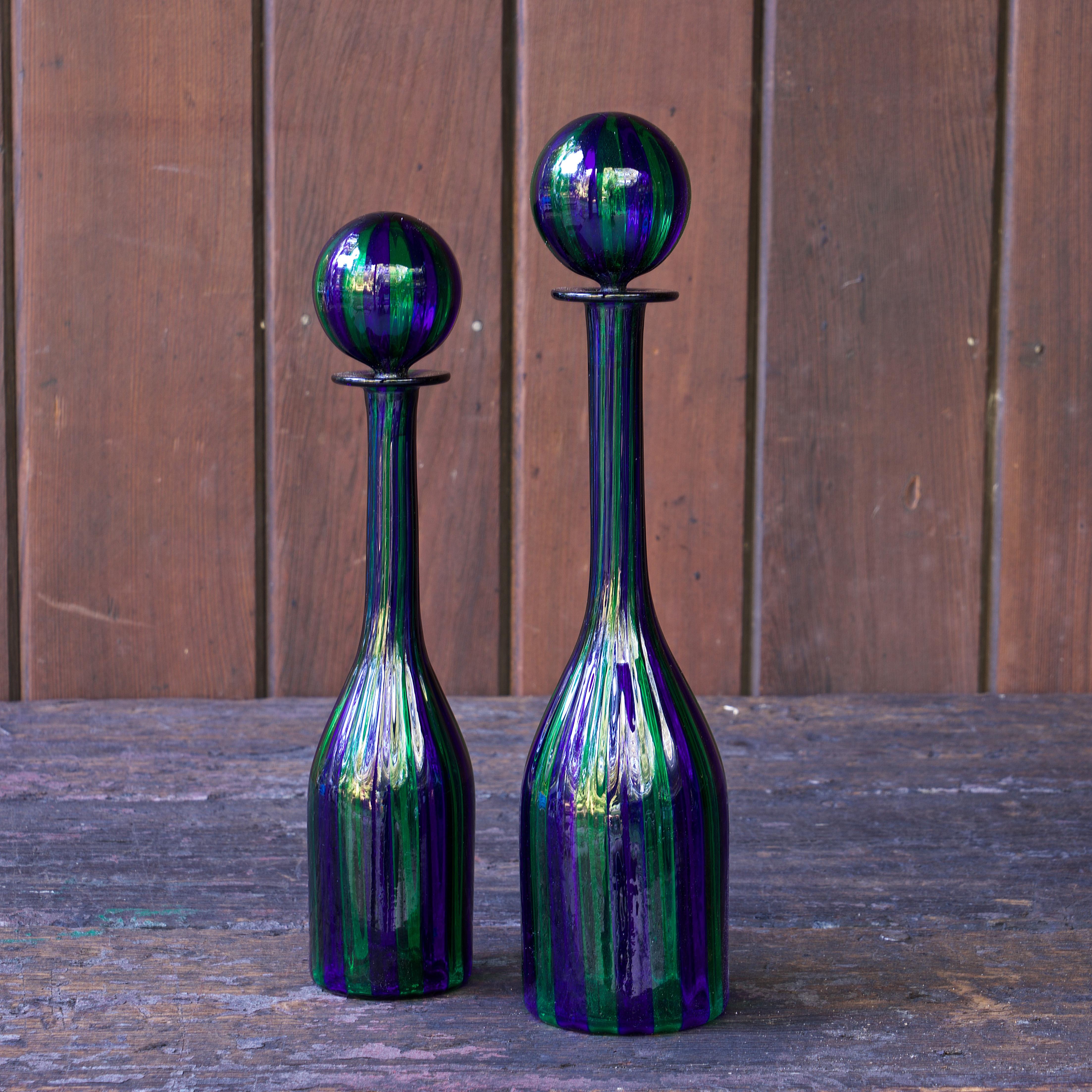 Unknown design/maker, unsigned, possibly Murano.

An amazing pair of hand-blown art glass bottles with matching stoppers.  Thin walled, striping all through botles and the stoppers.  High quality mid-century made. Both have small pontil marks to