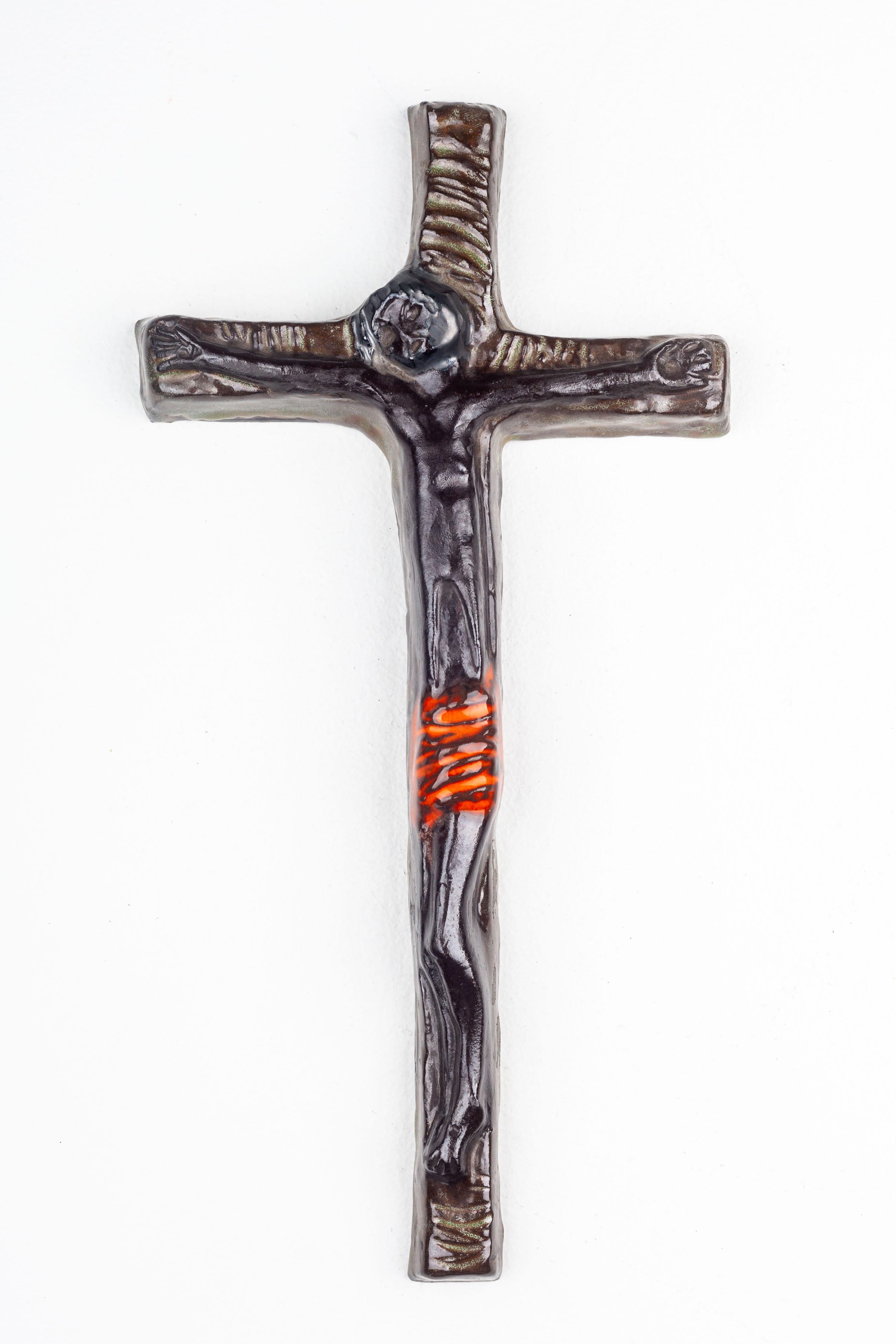 Ce crucifix en céramique est une représentation profonde de l'art moderne des studios européens du milieu du siècle dernier. Fabriqué à la main avec précision et soin, il reflète le mélange caractéristique de l'époque de thèmes traditionnels et de