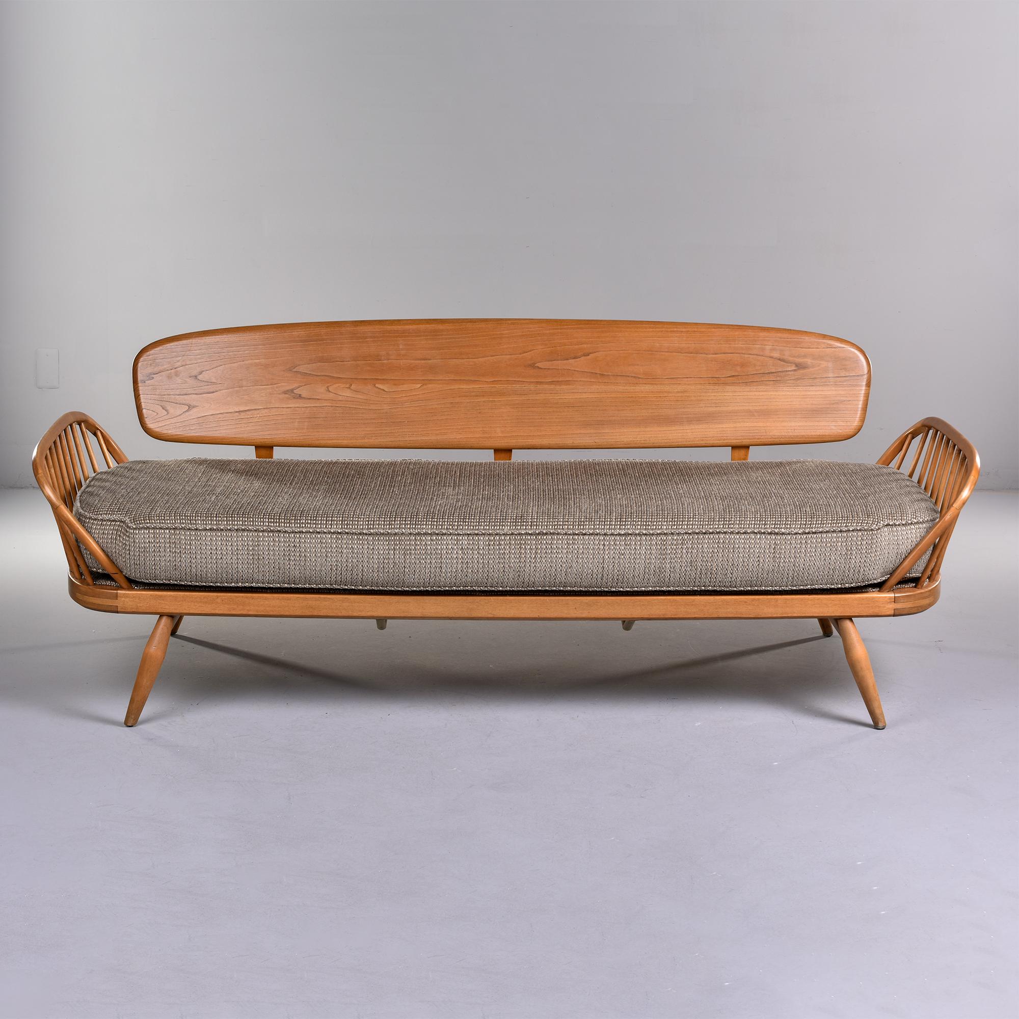 Circa 1960 ash framed day bed with new upholstery. Found in England, this has new webbing, all new foam and upholstery fabric is a neutral, nubby chenille. Day bed or studio couch frame has side / arm supports, tapered and splayed legs and a back
