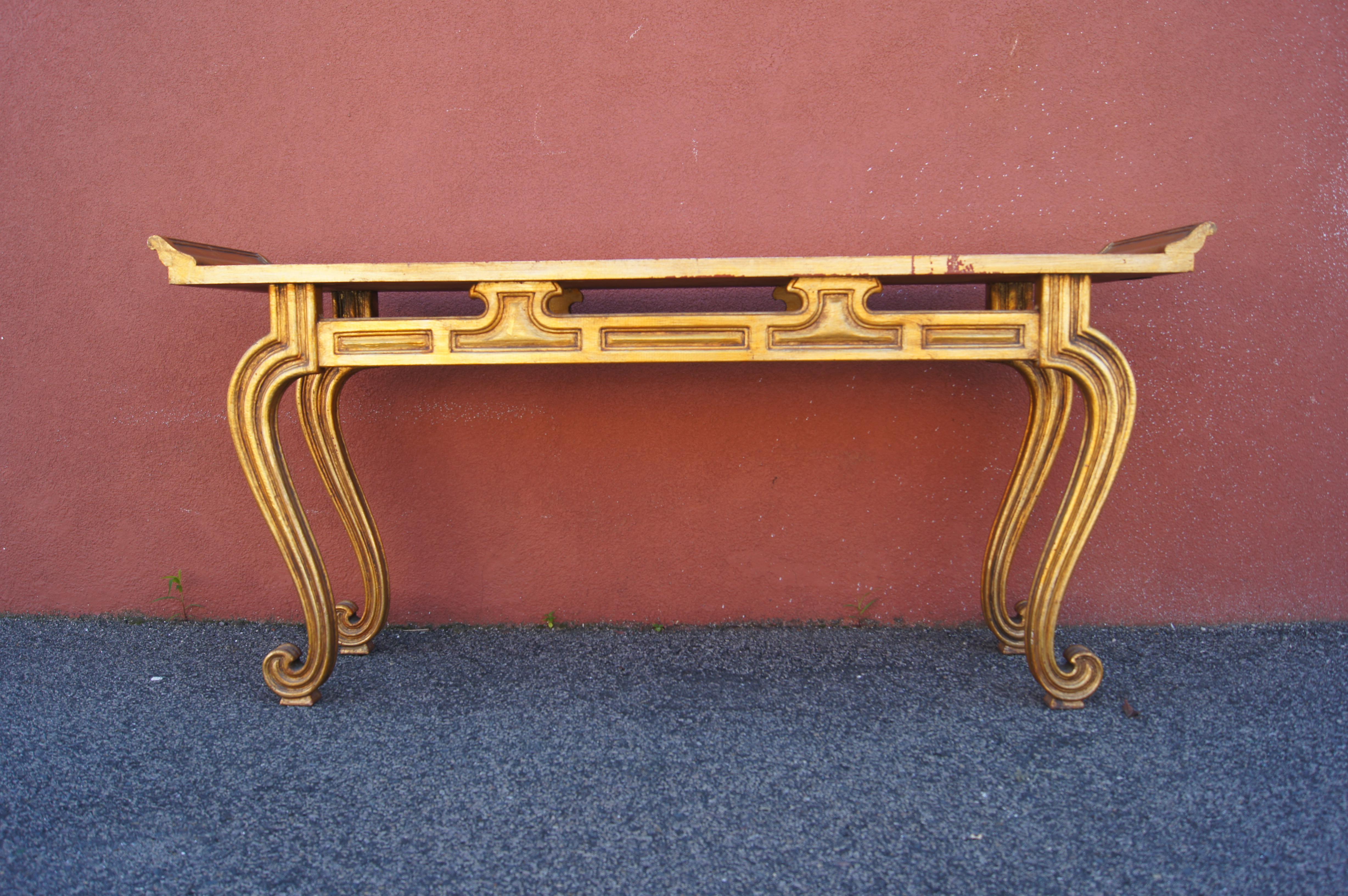 This console table is a 1950s interpretation of the altar tables traditionally found in Chinese reception halls. The gilt-painted wood frame features the typical everted flanges and scrolled legs; the table surface is gold-specked mirror.

The