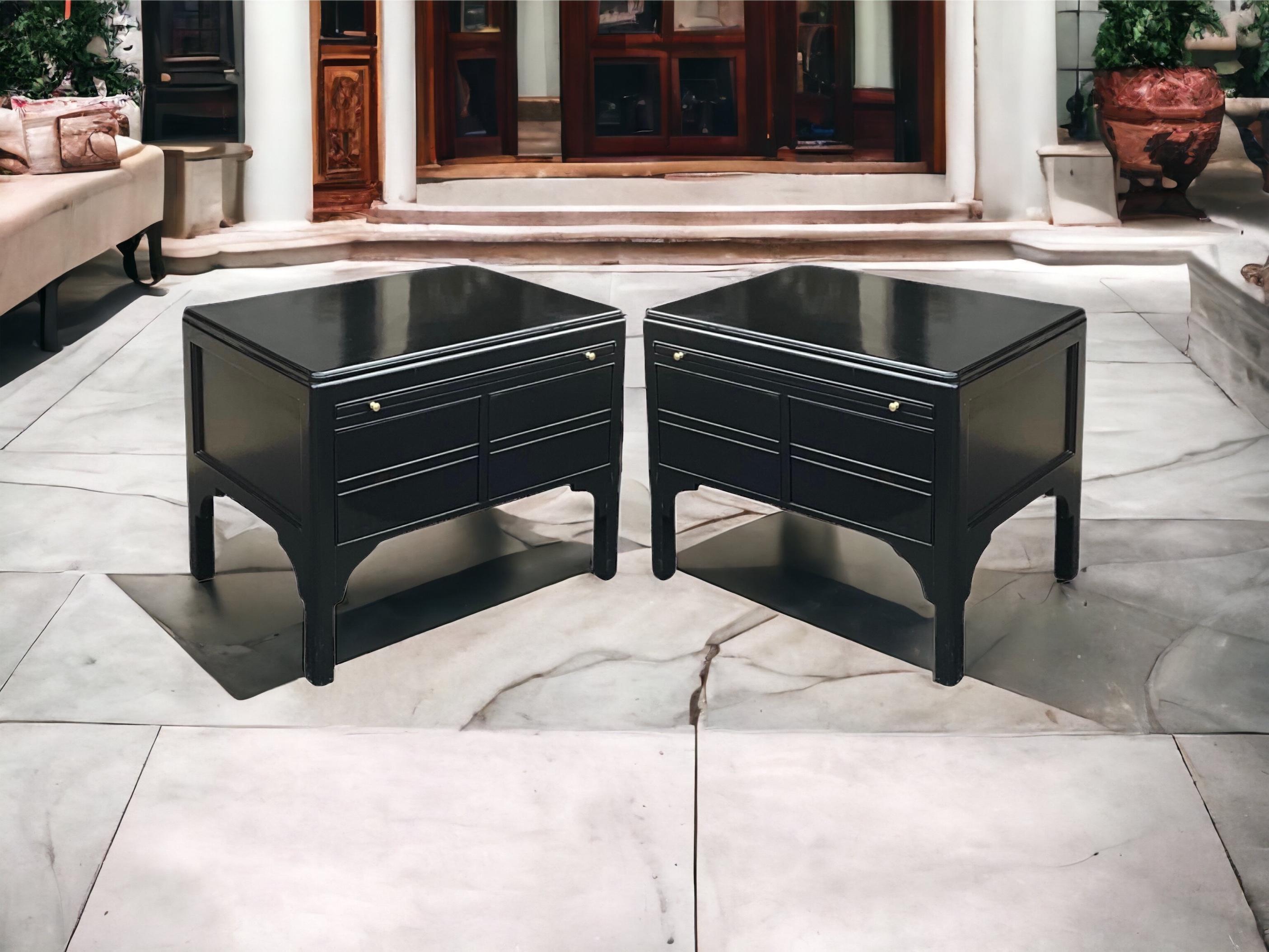 This is a pair of mid-century modern low profile black lacquer side tables or chests. Each has a draw leaf writing surface. The lacquer finish is vintage. They are unmarked and in very good condition. The addition of a little brass pull to match the