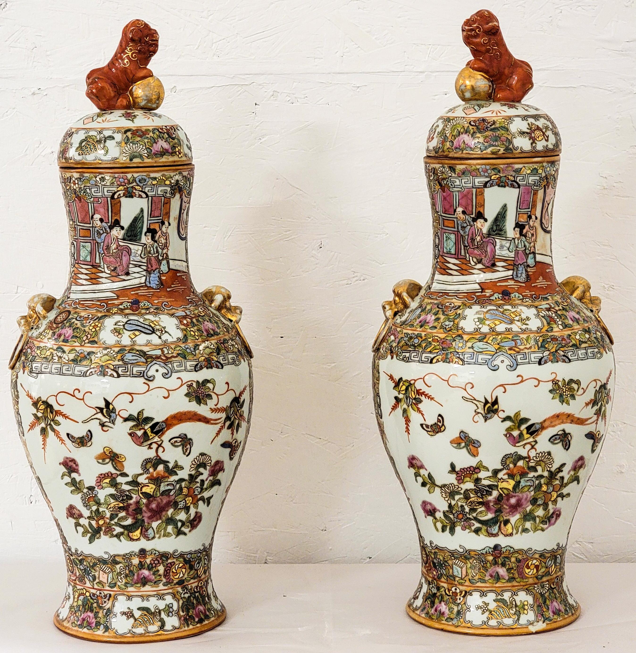 This is a very decorative pair of Asian ginger jars with vibrant colors and pastoral scenes. They have gilt accents and foo dog finials. They are marked and show some lite age wear.
