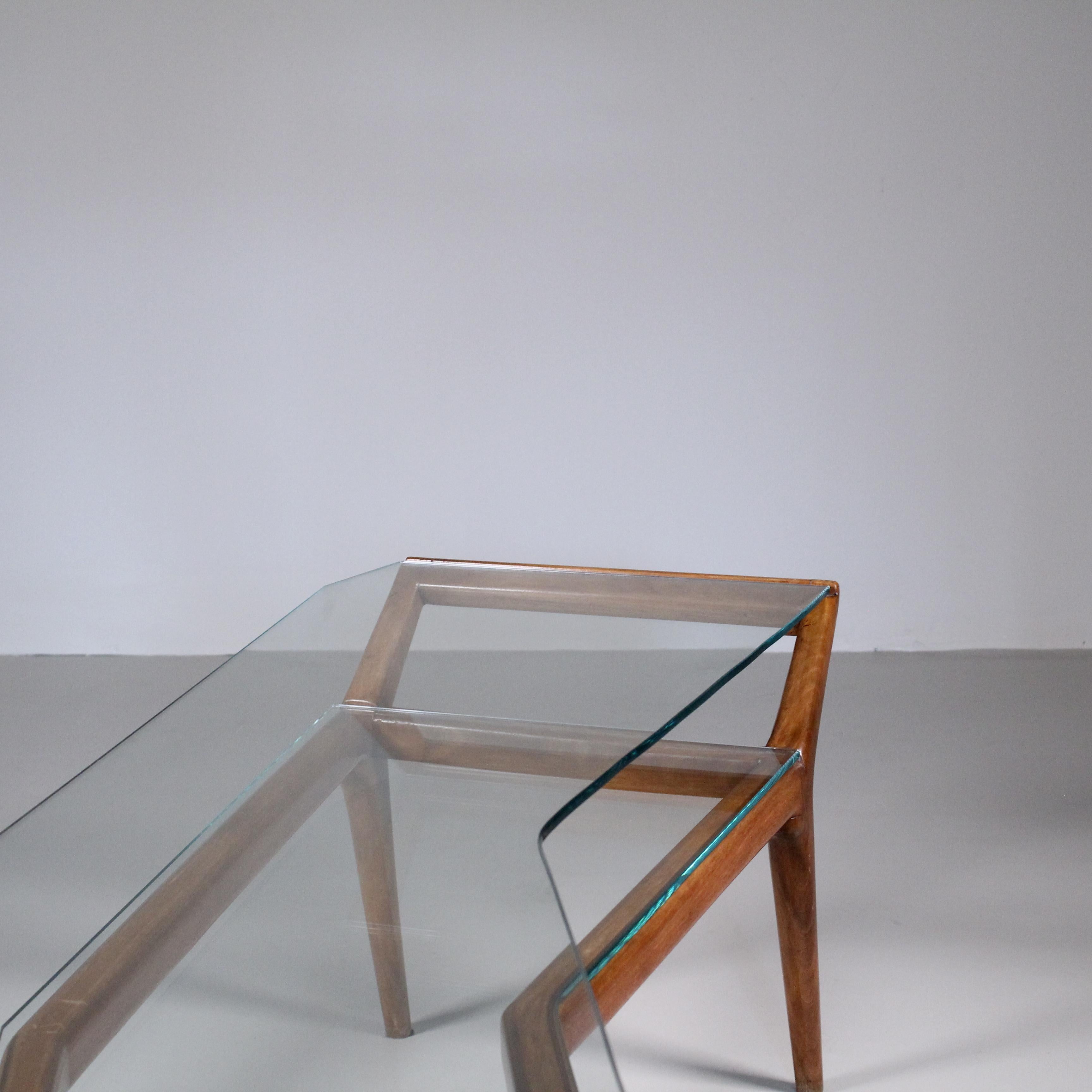 A coffee table with an asymmetrical design in wood and glass, with a mid-century-inspired style, for which we cannot find an attribution unfortunately. But the quality is so high and the object from life is so incredible that we find it hard to