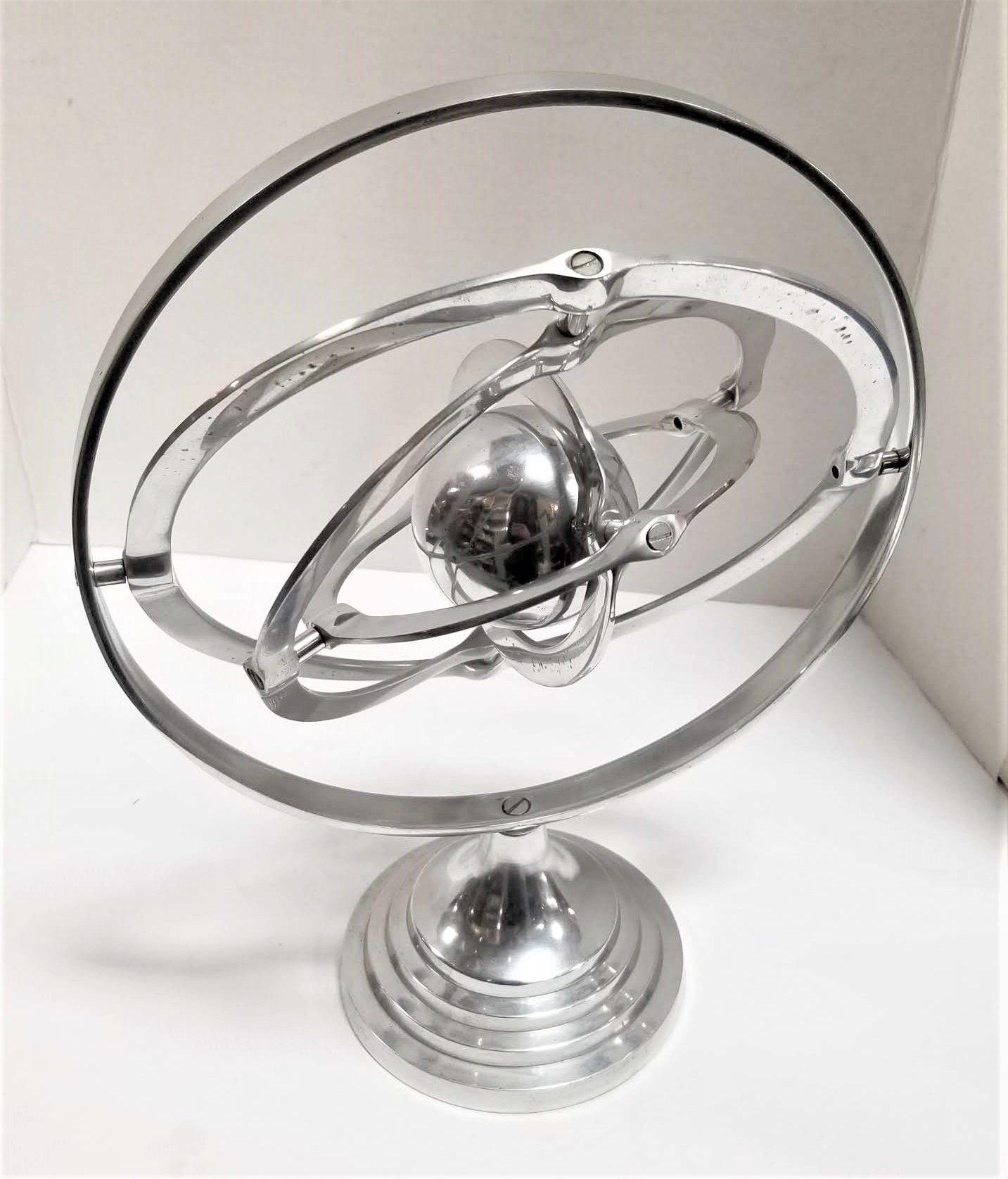 Midcentury silver armillary style tabletop kinetic sculpture mobile featuring rotating spheres
An 