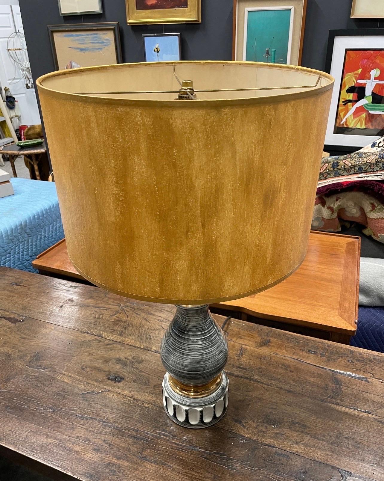Une fantastique lampe de table noire et blanche avec des accents d'or 24kt et un abat-jour doré peint à la main.  Cela date de l'ère atomique.  La lampe est en céramique et ne présente ni éclats ni fissures. Les mesures sont celles de la lampe, de