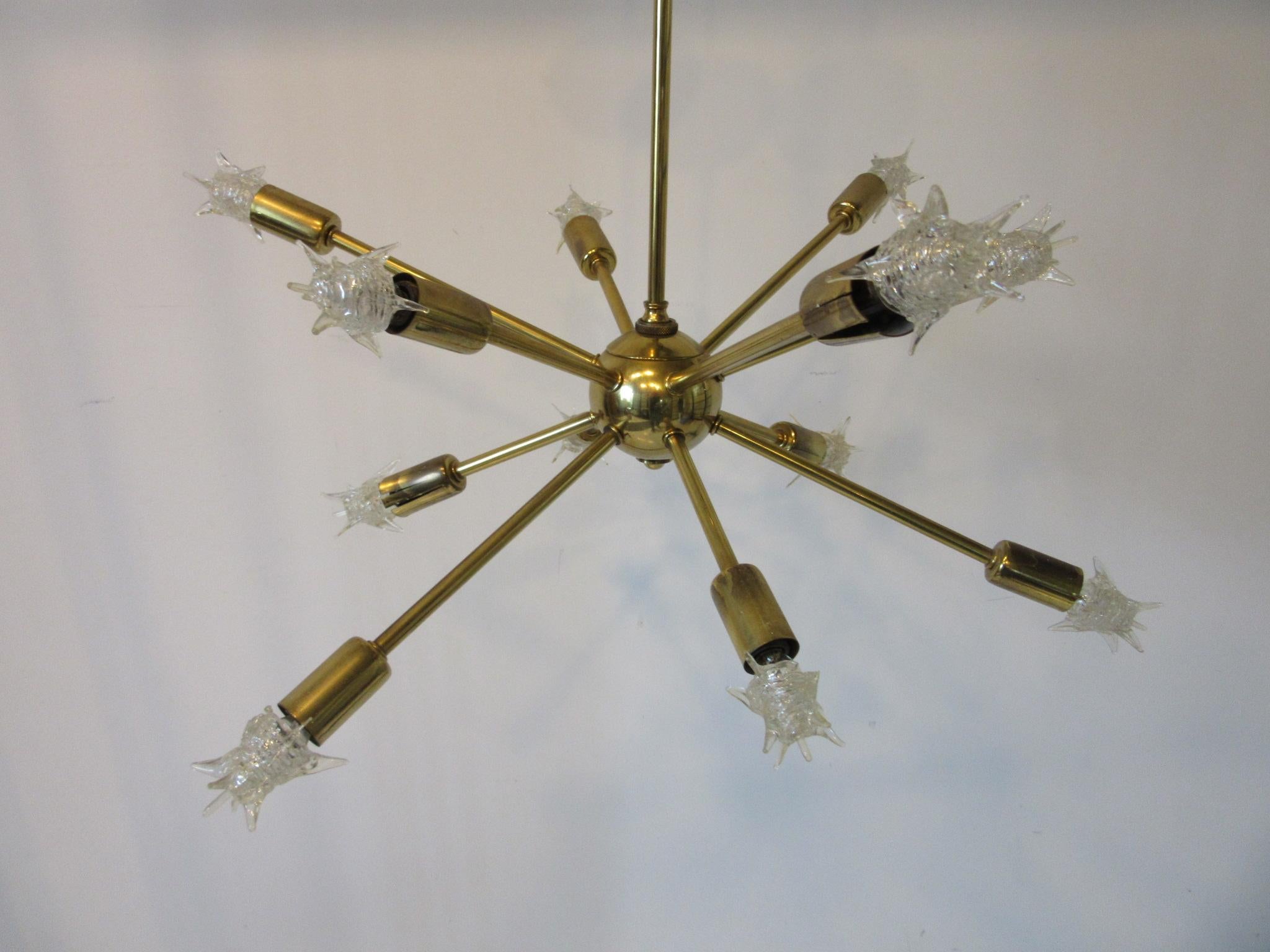 A brass midcentury atomic Spunik chandelier with twelve arms having the original styled starlight vintage bulbs which are still available. This fixture is a statement of the fun and funky Space Age 1950s style with the arms radiating out of the