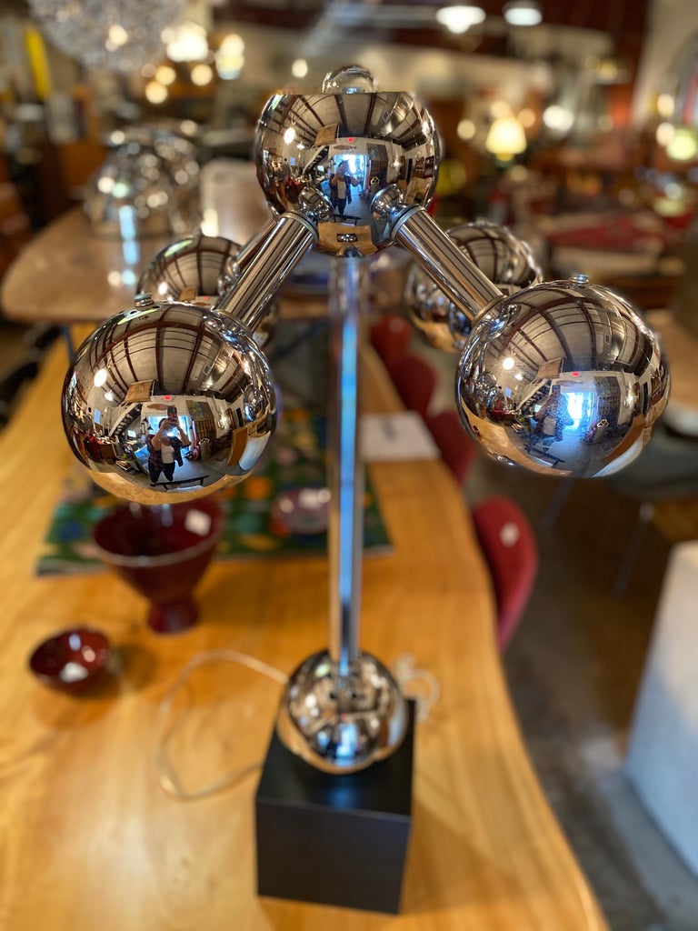 Mid-Century Modern chrome atomic styled table lamp on a block base features four downlights and one uplight in the style of J.T Kalmar, circa 1970s. This vintage table lamp is in good overall condition.