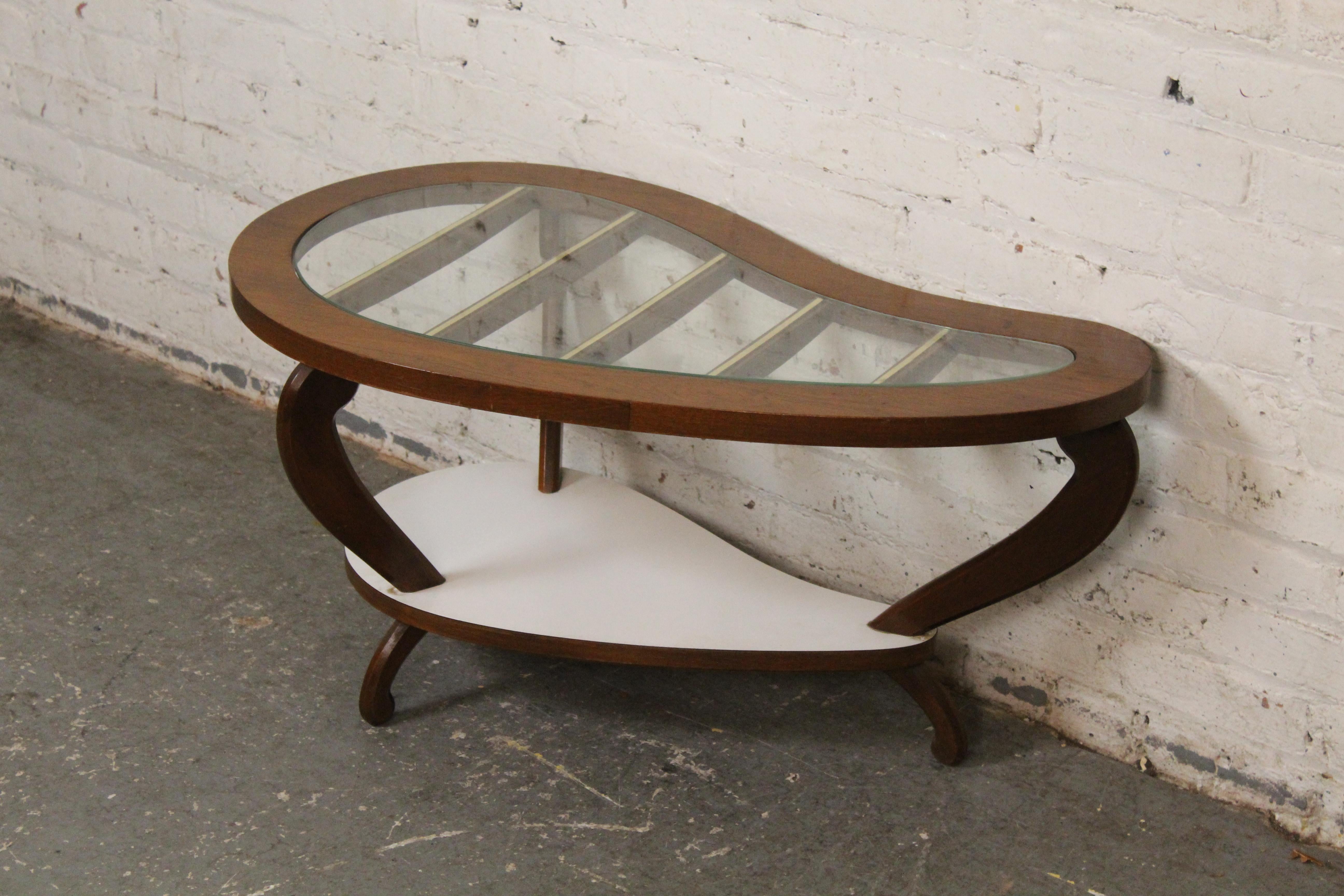 Apportez à la maison tout le plaisir de l'ère atomique avec cette petite table à haricots amusante. Dotée d'une forme biomorphique unique, cette table à deux niveaux présente un plateau inférieur en stratifié blanc et un plateau en verre parfait