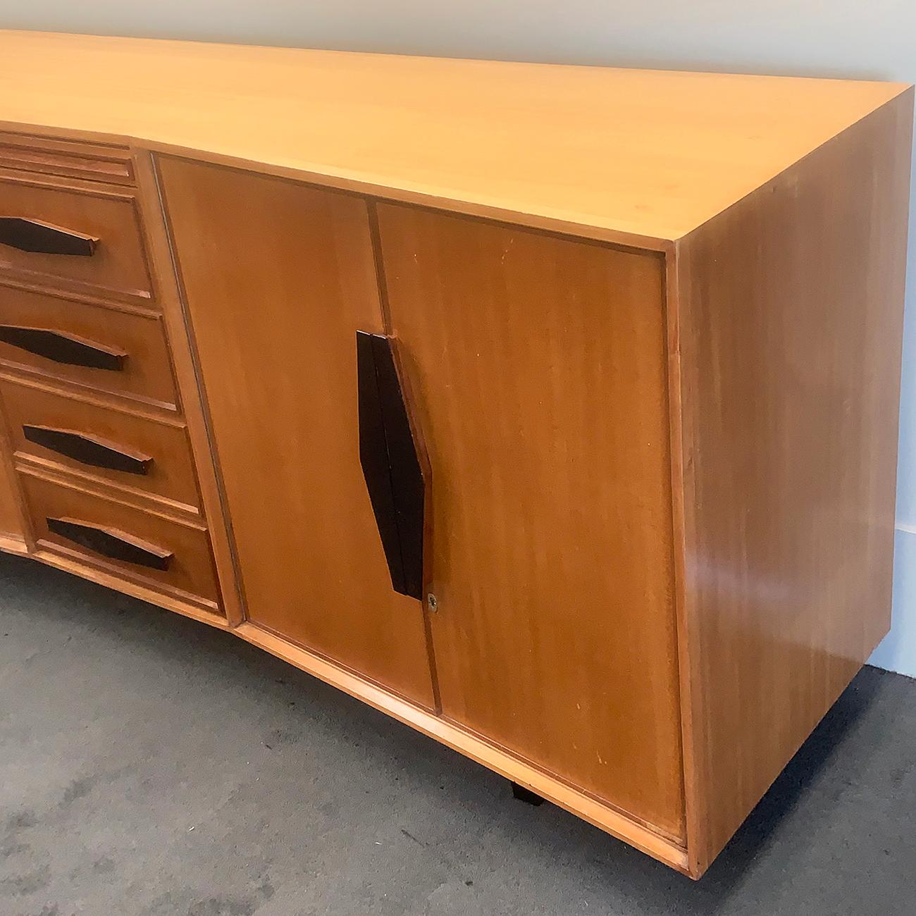 Art Deco long Australian sideboard, with two side cabinets and fitted drawers to centre. The handles to all, are black geometric, all with 5 sides. The left and far right doors cover 2 inner, large slide out shelves, the right side set are lockable