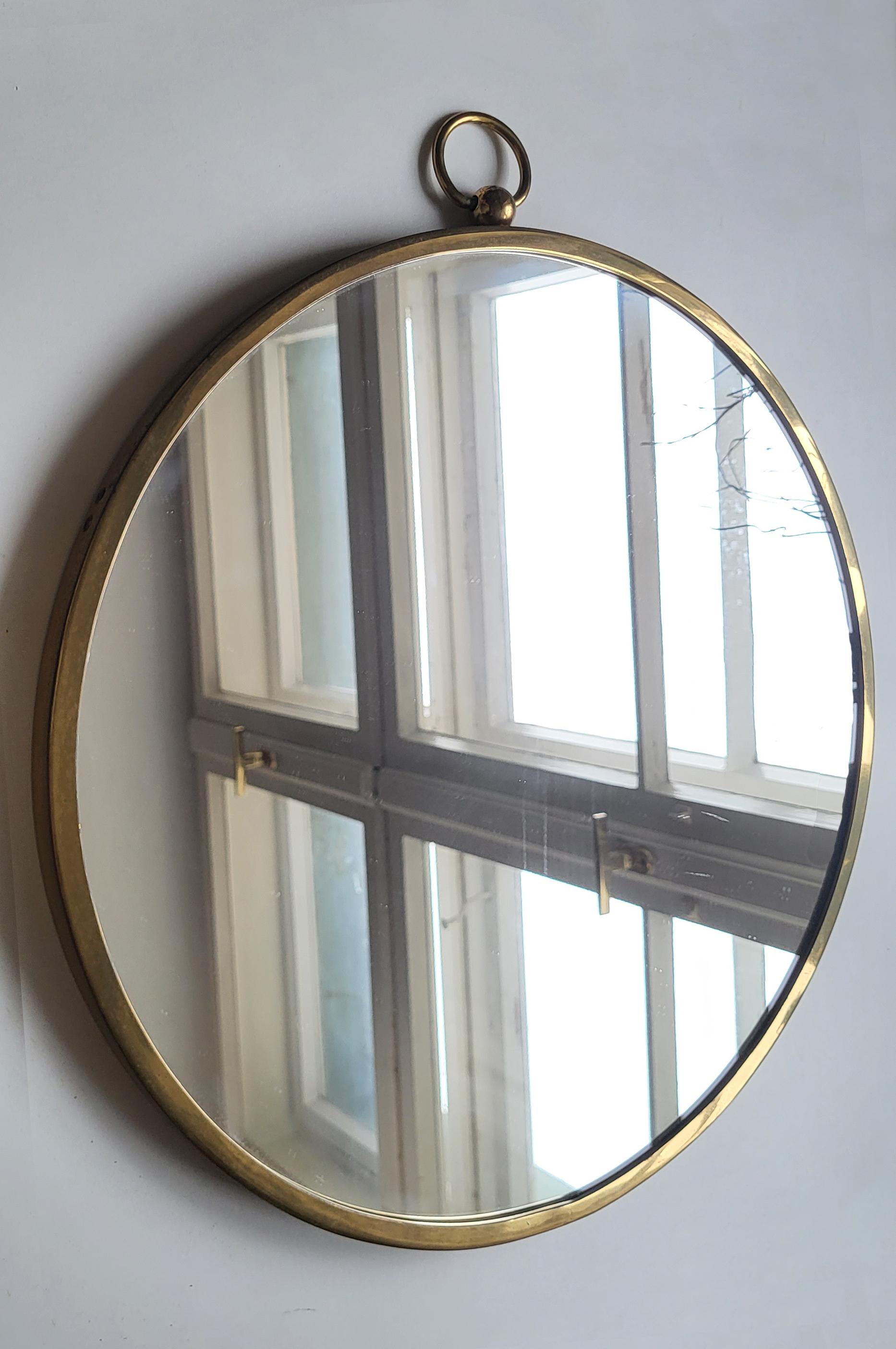 Wonderful mirror with brass frame and a decorative brass ring. 
Austria, 1950s.