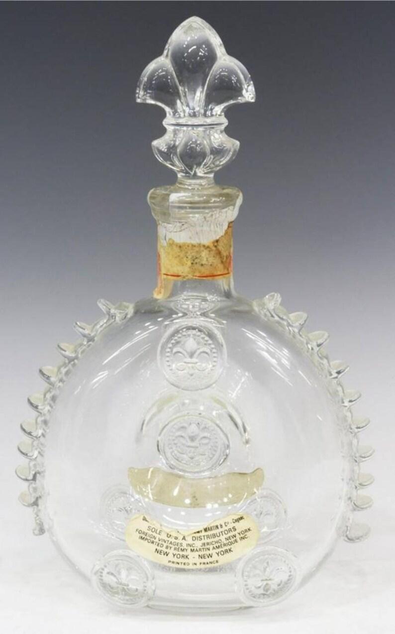 Une magnifique carafe Louis XIII en cristal soufflé à la main de Baccarat, pour Remy Martin & Co. Cognac, délicieusement fabriqué à la main en France, avec un motif de fleur de lis en relief, des côtés détaillés en volutes, le bouchon d'origine en