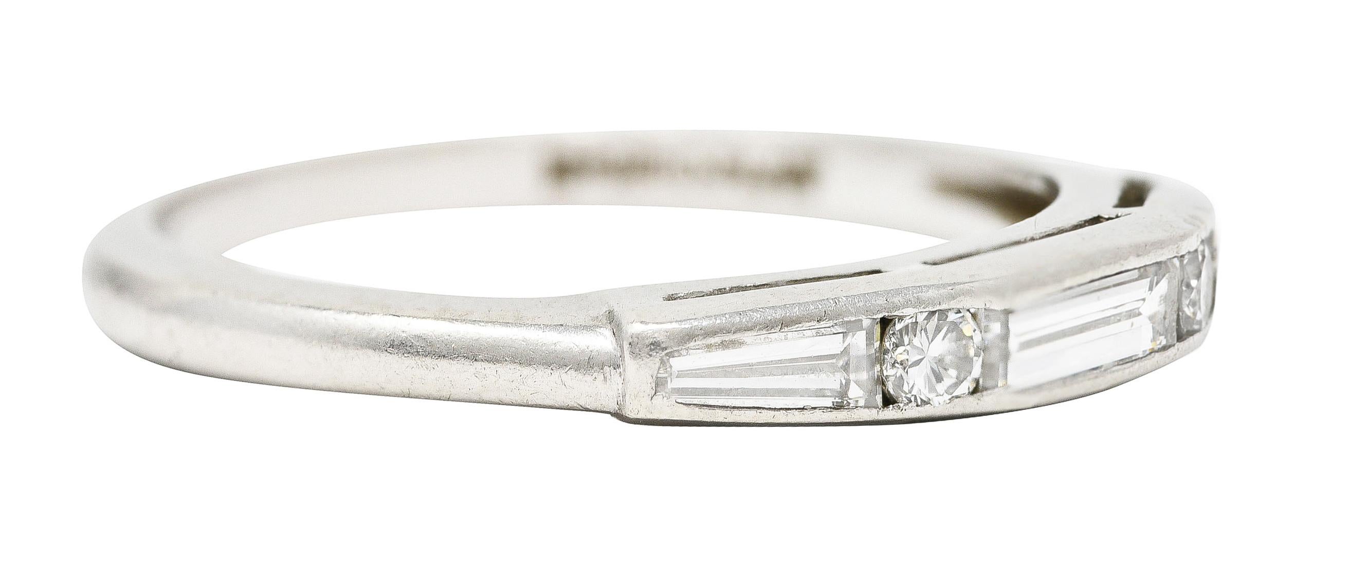 Centering a baguette cut diamond flanked by tapered baguette cut diamonds. Weighing approximately 0.20 carat total - G/H colorwiht VS color. Channel set East to West and alternating with single cut diamonds. Weighing approximately 0.06 carat total -