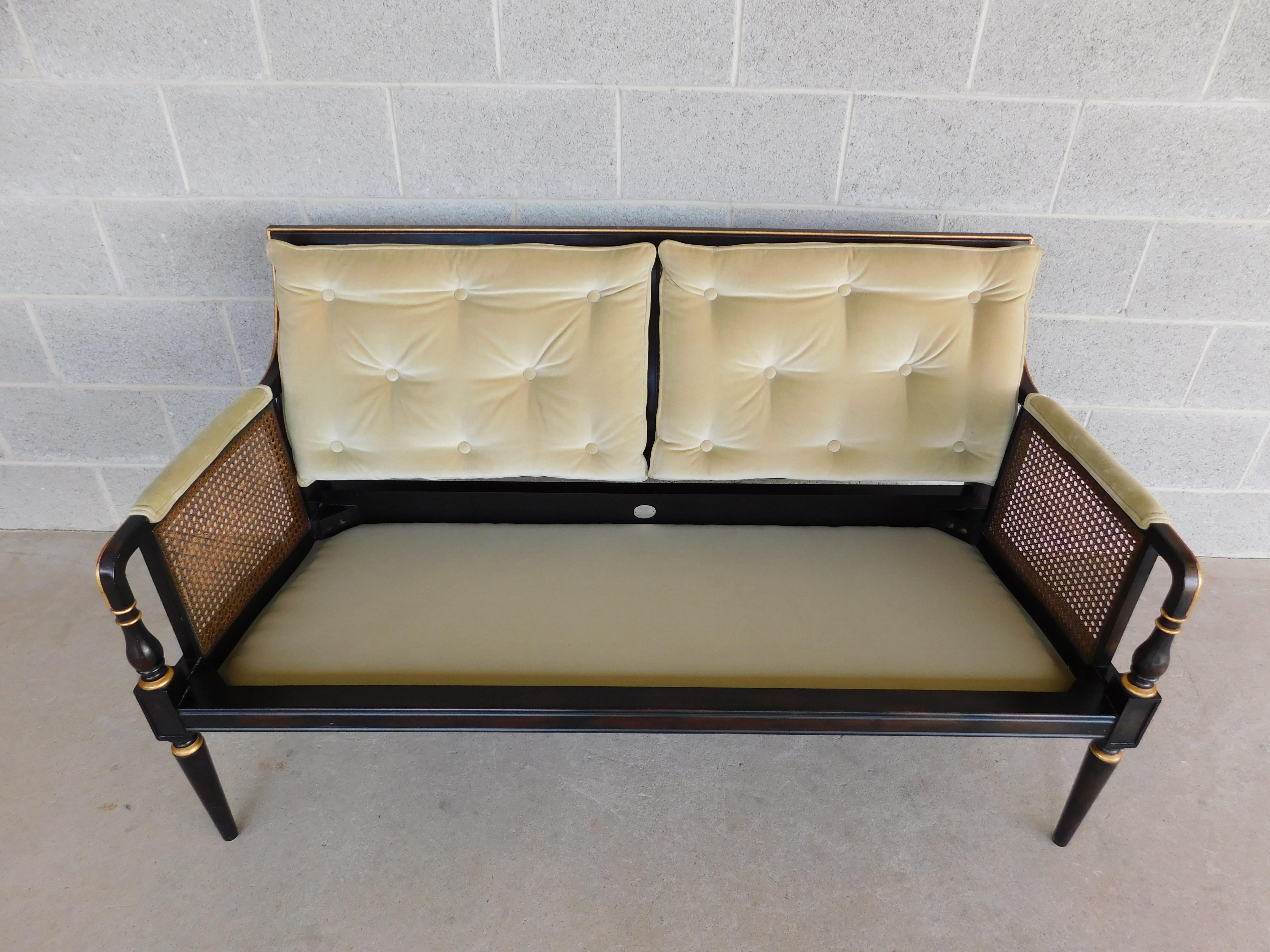 Midcentury Baker Furniture Regency Style Sofa mit schwarz lackiertem Rahmen. Serpentinenförmige Rückenlehne im Lendenwirbelbereich mit Caning in der Mitte. Gerollte Armlehnen über geschwungene Seiten in konischen Beinen, abnehmbares Sitzkissen.