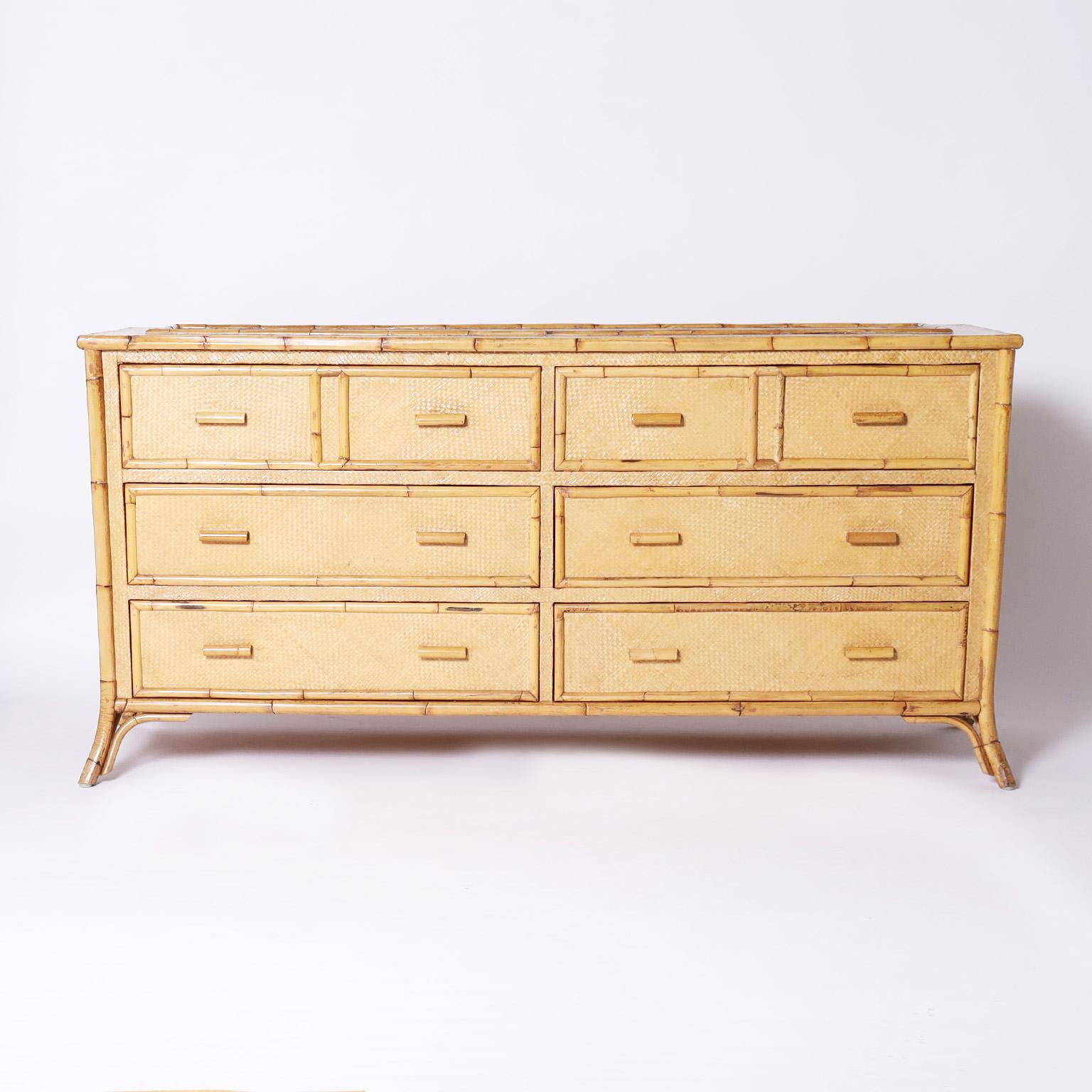 British colonial style chest with six large drawers for plenty of storage crafted with a bamboo frame having grasscloth panels all around and featuring a sun ray motif on the sides.