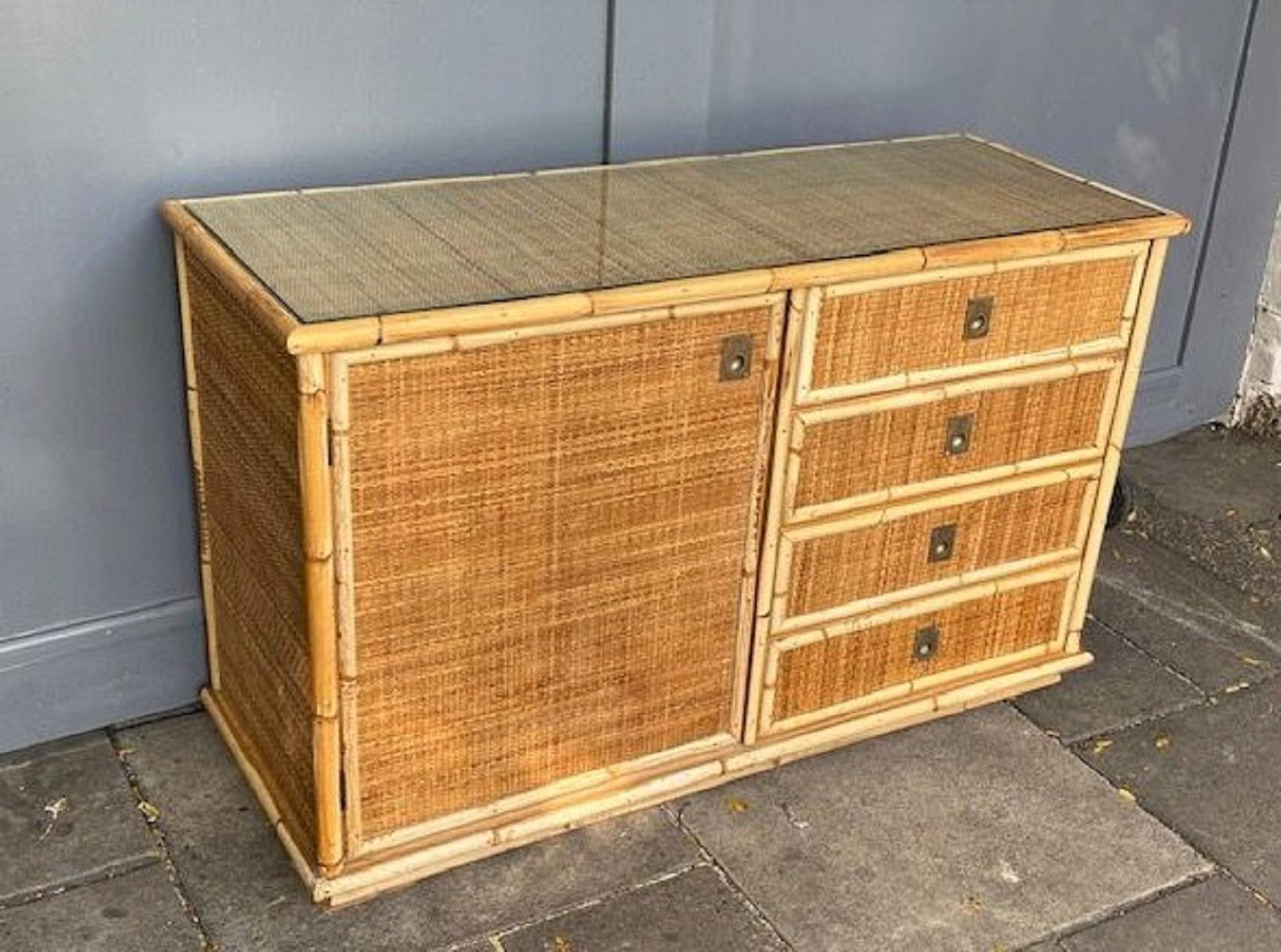 Mid-century Rattan / Cane sideboard by Dal Vera, Italy 1970s.

Beautiful Dal Vera rattan sideboard. Wooden structure with rattan and cane detail, covered in close weave matting, with cane handles. Opening with a door and four drawers, with solid
