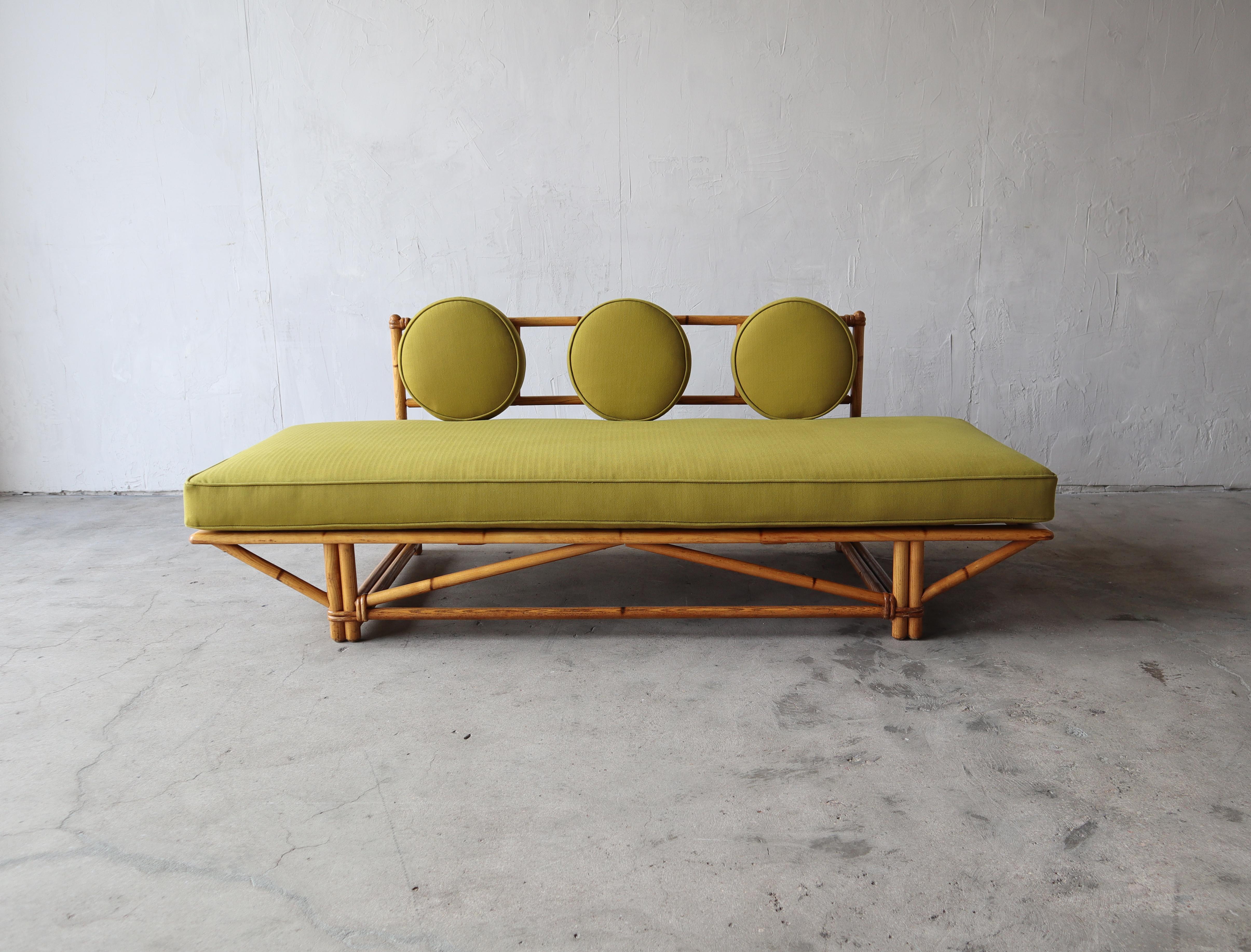 Stunning example of vintage bamboo. This gorgeous bamboo daybed sofa has show stopping lines and will add warmth and texture to any space. It has been modernized with all new foam and fabric and stylish round back cushions, taking it from kitch and