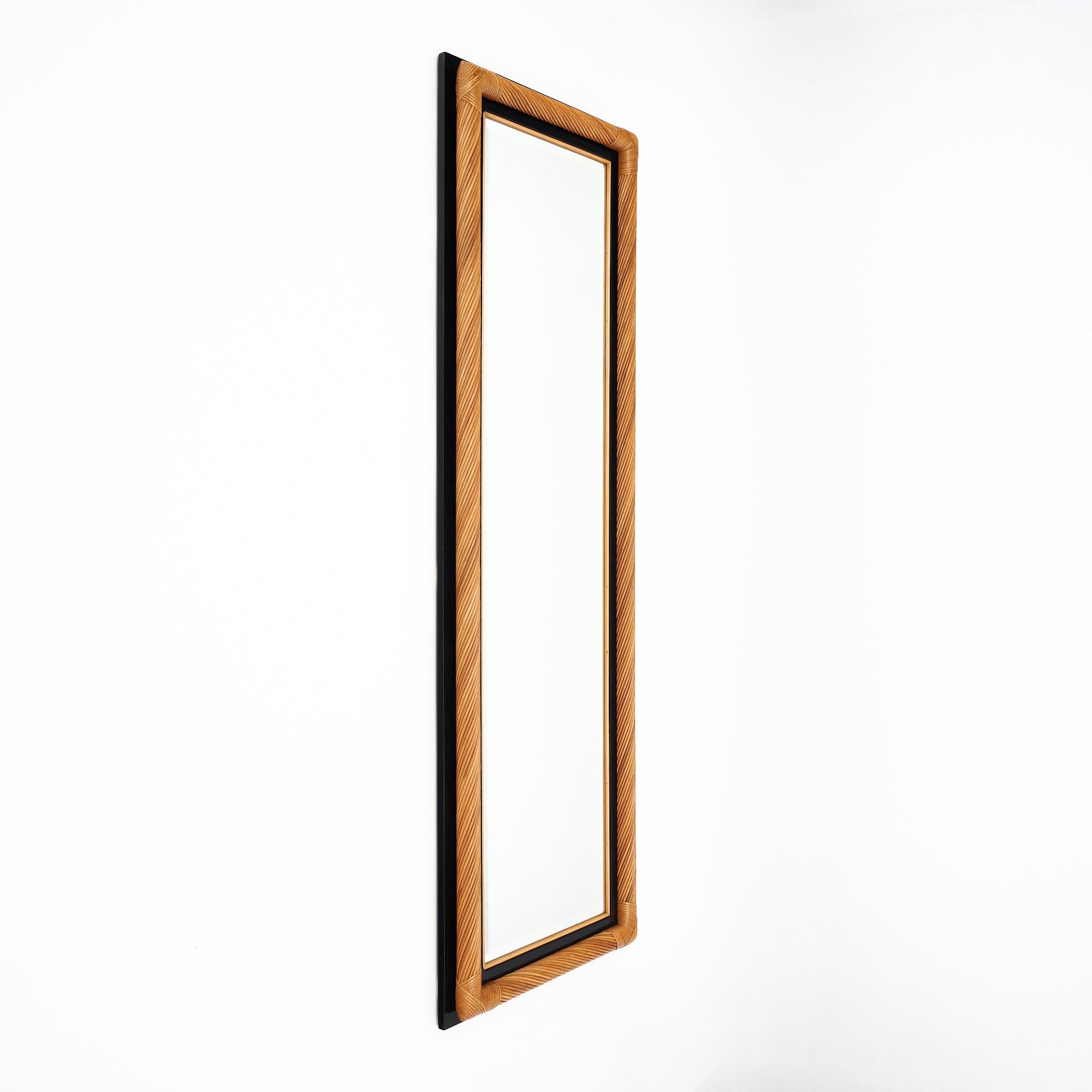 Full length mirror featuring a frame of twisted bamboo and ebonized wood. The central rectangular mirror is beveled on the edges. This piece is in excellent vintage condition. The photos accurately depict the condition.

