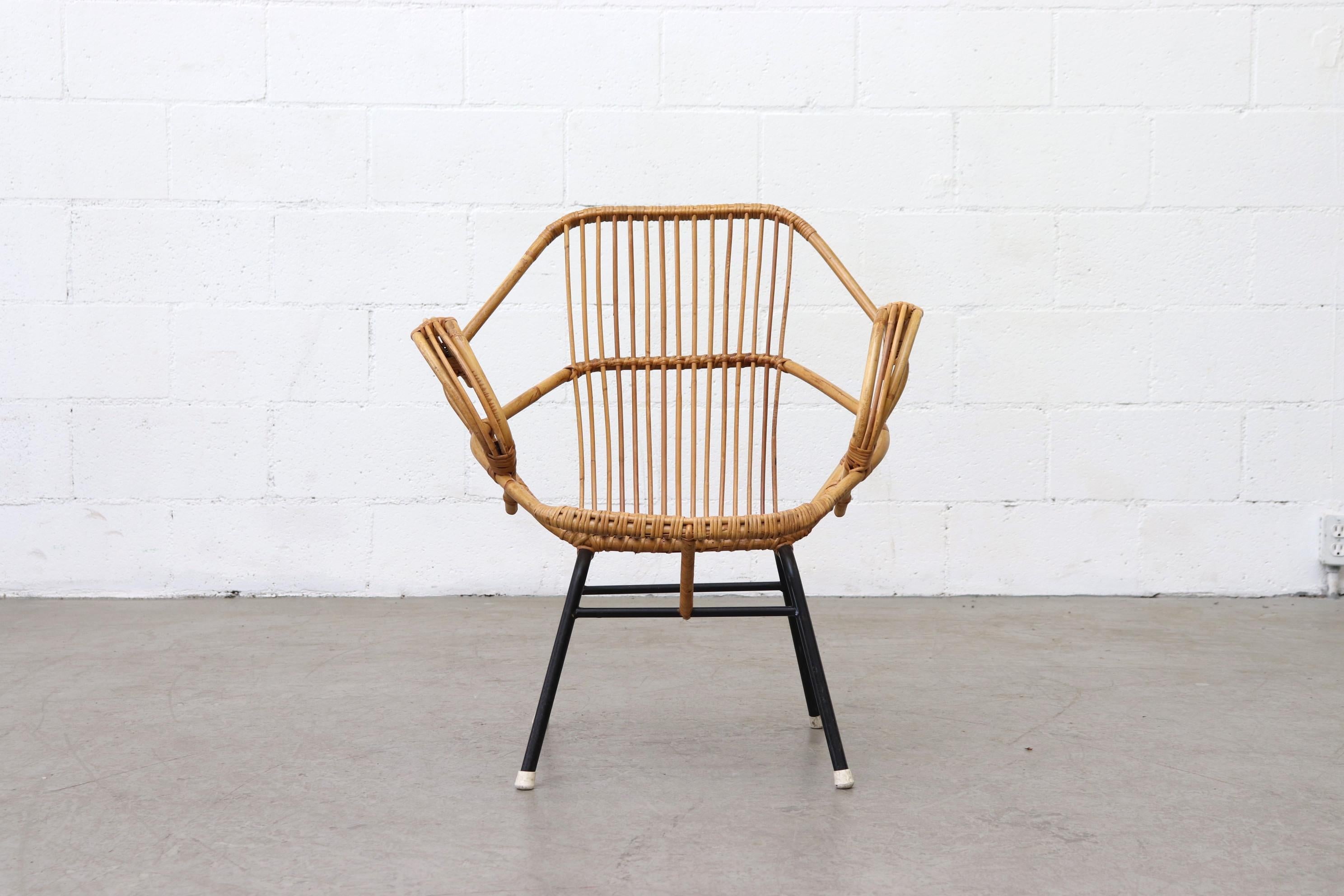 Geometric hexagon shaped bamboo lounge chair with arms, black enameled metal frame and white rubber feet. In original condition with some signs of wear consistent with its age and use. Other bamboo chairs and sofas available, listed separately.