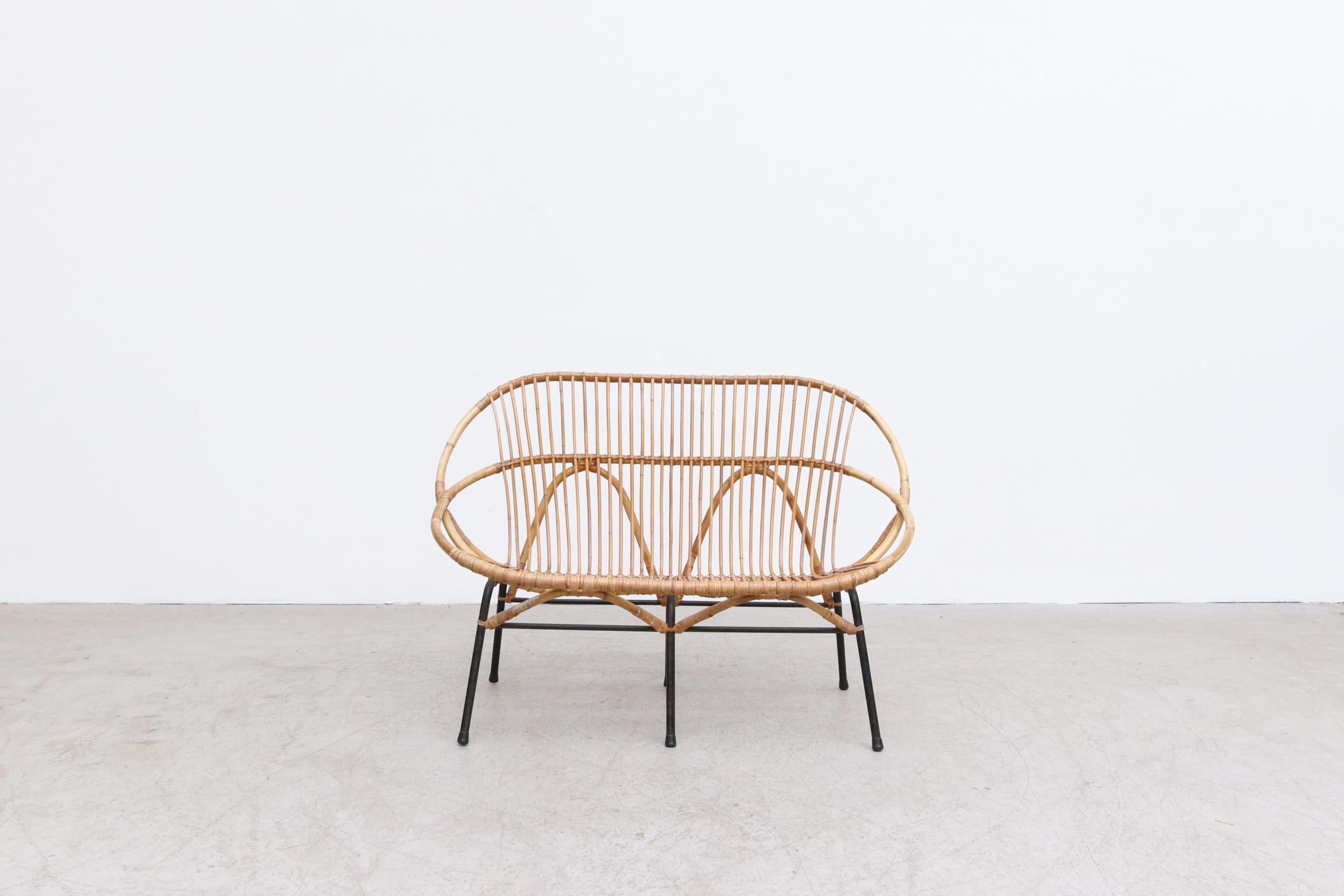 Mid-Century bamboo loveseat with black enameled metal frame by Rohe Noordwolde. In original condition with some signs of wear consistent with age and use. Suitable for outdoor use with proper care and maintenance under dry, protected, covered area