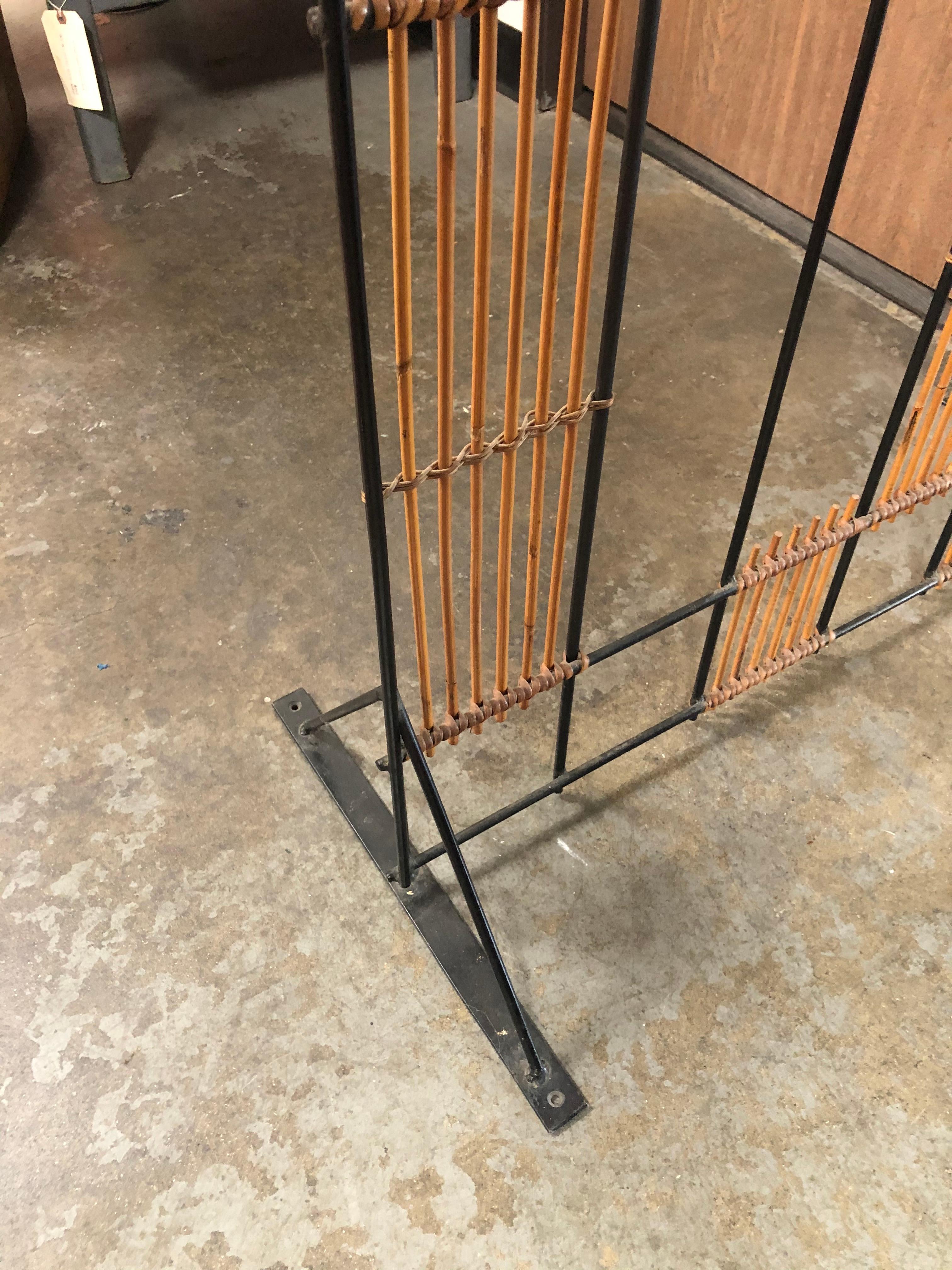 Midcentury bamboo screen is a great piece for most any room or vignette. This beautiful screen is built with a metal frame with bamboo designs throughout. Screen has feet two pronged feet to be freestanding. Would look great as a room divider, plant