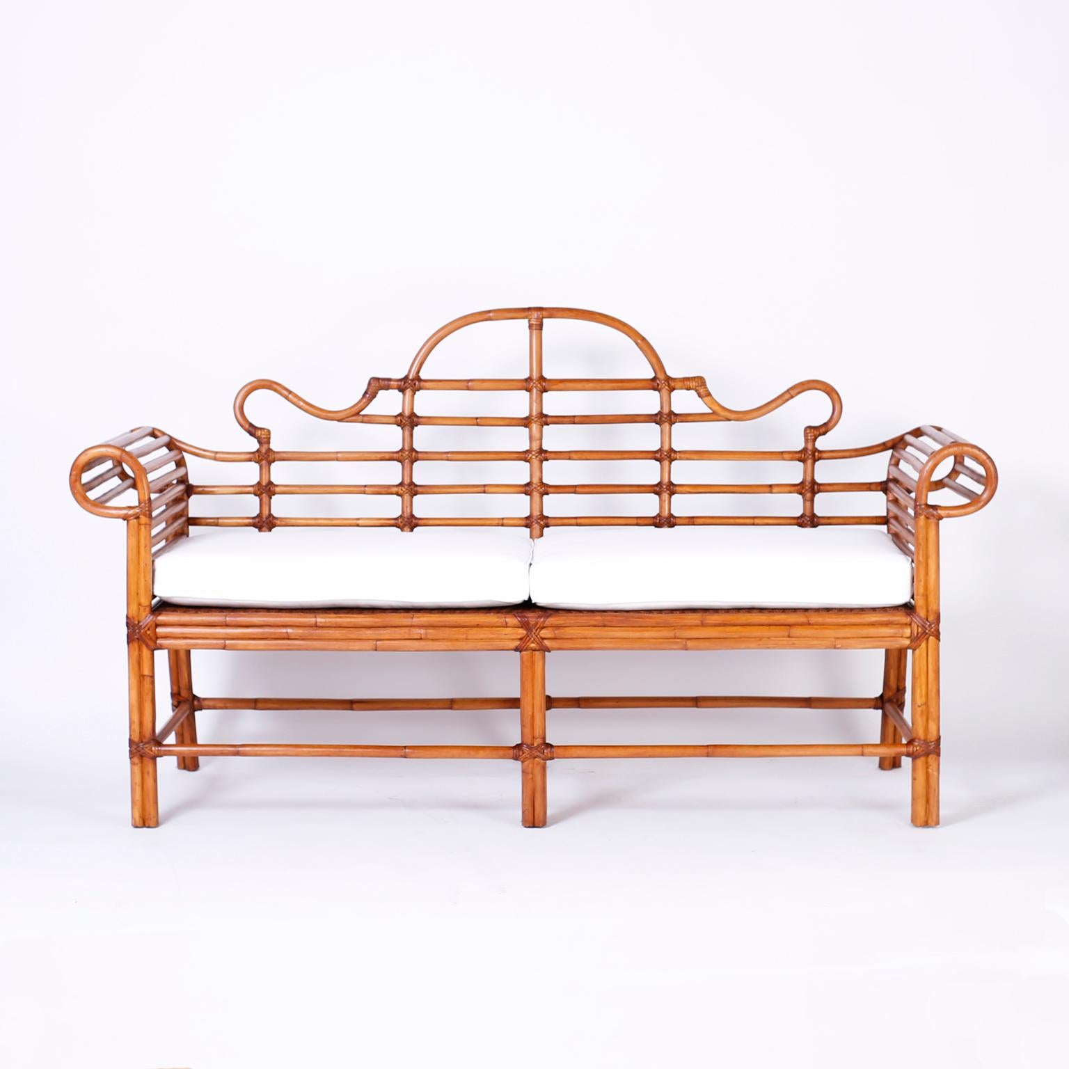 British colonial style bamboo and bent bamboo settee with reed wrapped joints, hand caned seat, and a casual elegant form.