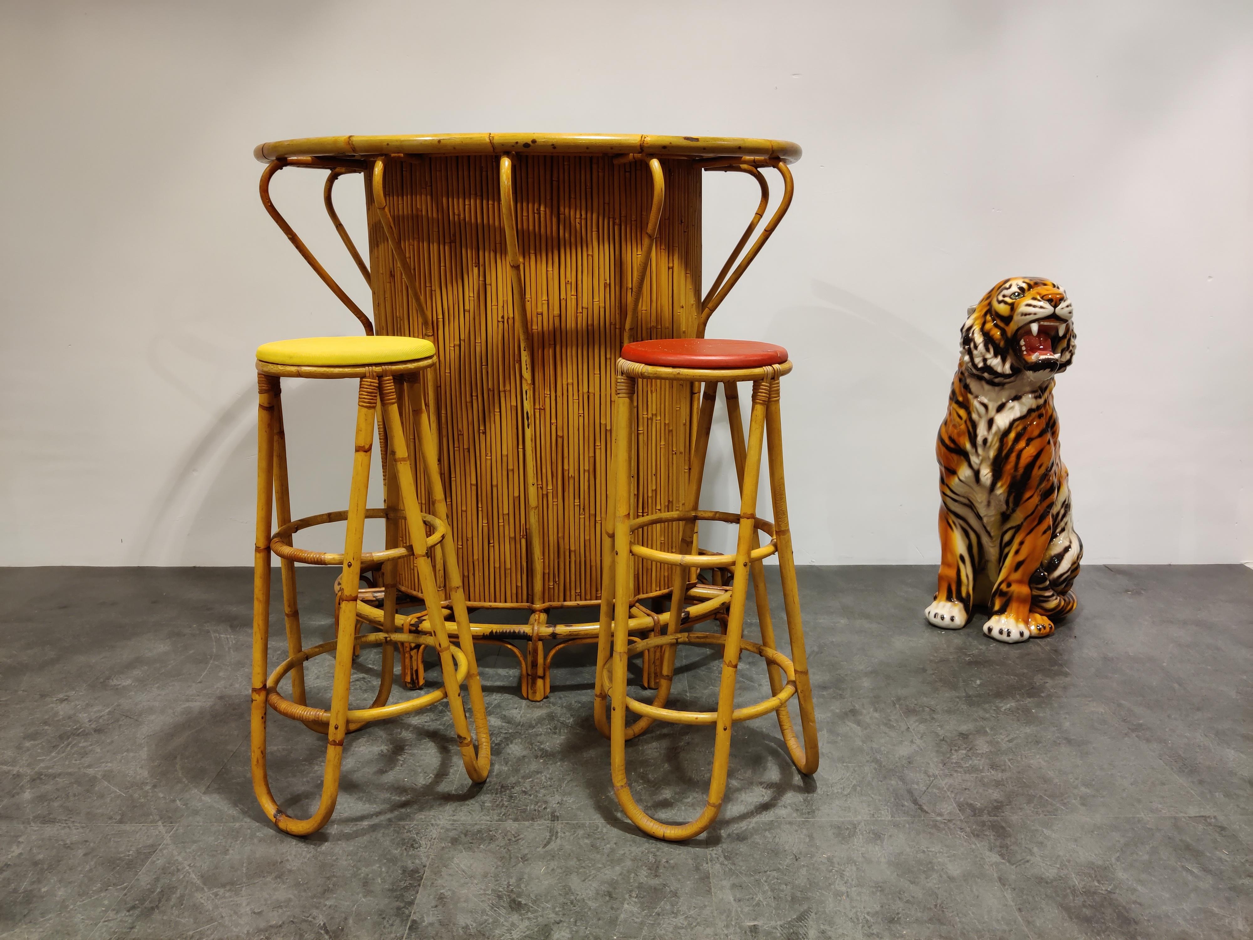 Lovely Tiki bar in bamboo for sale with a kidney shaped red Formica tabletop and two matching stools.

Very decorative item which has a 'happy' feeling about it.

Lovely to mix with some Regency kitsch.

Good overall condition. Small damage to