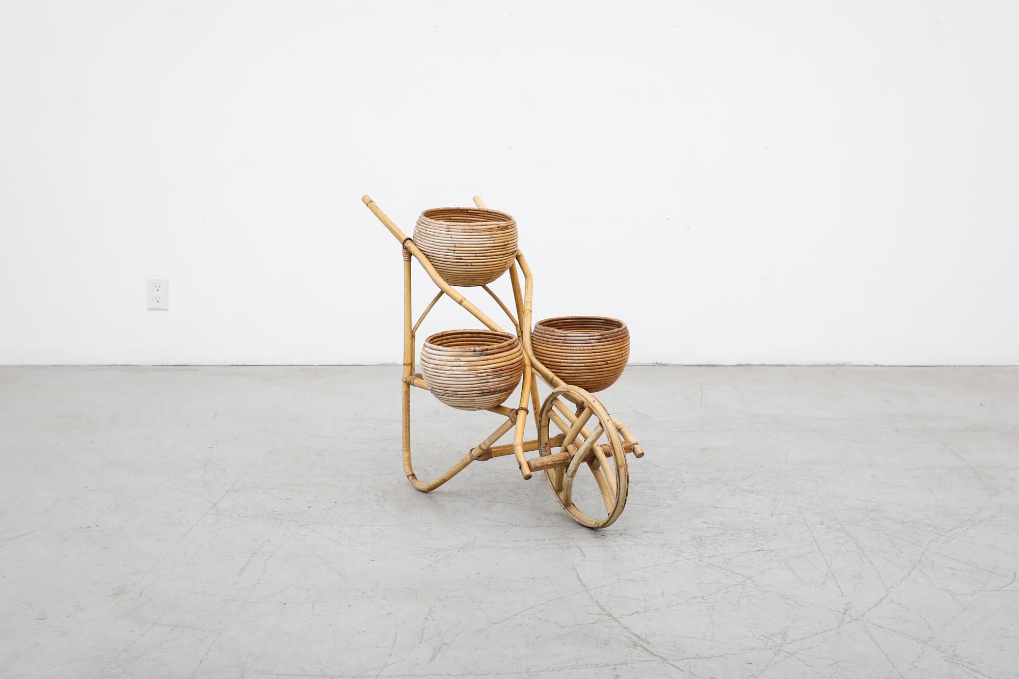 Charming, Vittorio Bonacina (attr), 1950's bamboo wheelbarrow with three planter baskets and one front wheel. In original condition with visible wear, including sun fading on one side, water marks and scratches. No structural damage. Wear is