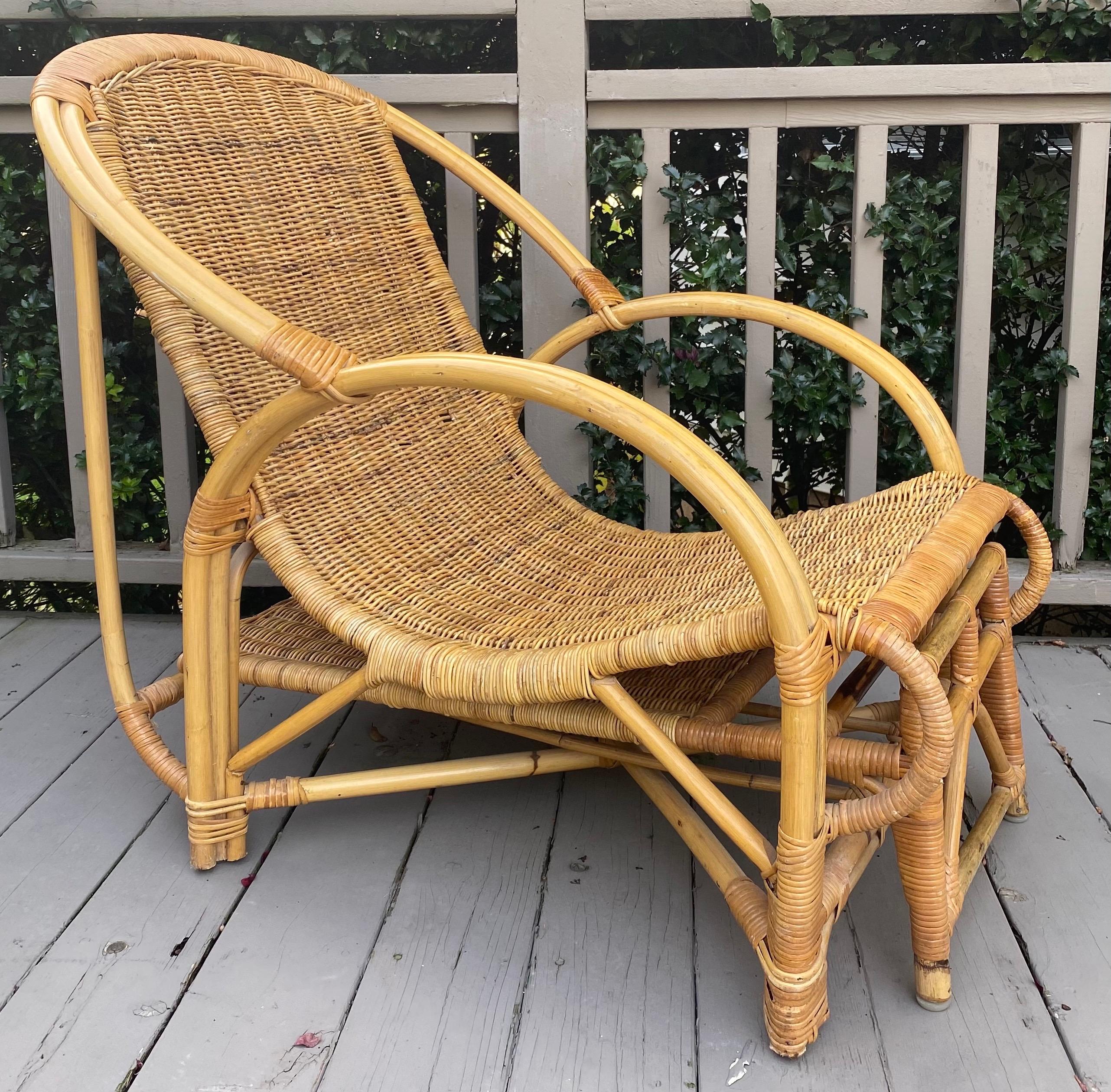Unique Mid-Century Modern wicker lounge chair with extendable pull-out ottoman. This sculptural chaise features a long pull-out ottoman which can be extended to desired position. The chair and ottoman frames frames are constructed of sturdy bamboo.